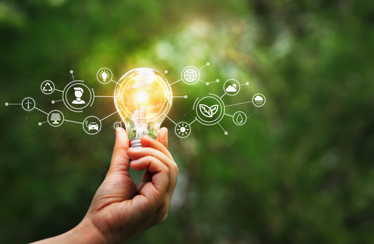 Hand holding light bulb on tropical nature background. Ecology and Environment concept. Energy of natural gas sustainable energy sources.