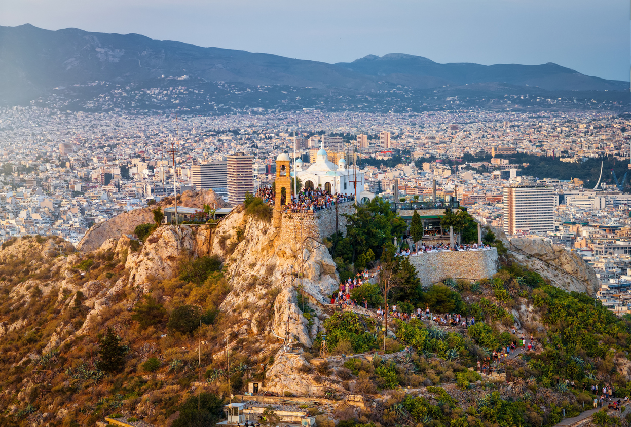 Aerial view of the top of Lycabettos Hill, Athens, Greece, with numerous tourist enjoying the summer sunset over the city skyline