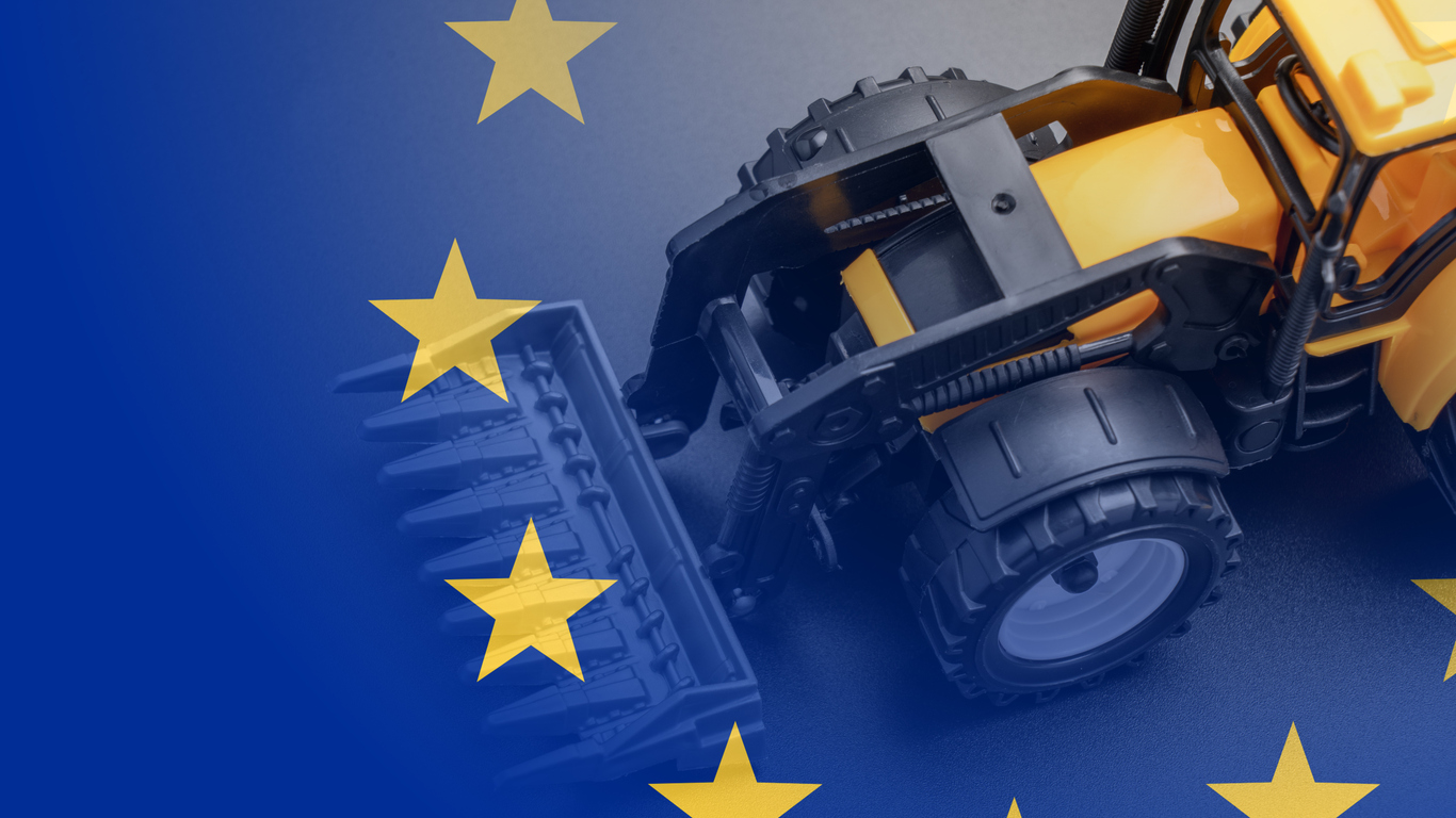 Yellow tractor on white background, European union flag, farmers planting concept. Tractor and flag of European Union. Close-up view from above.
