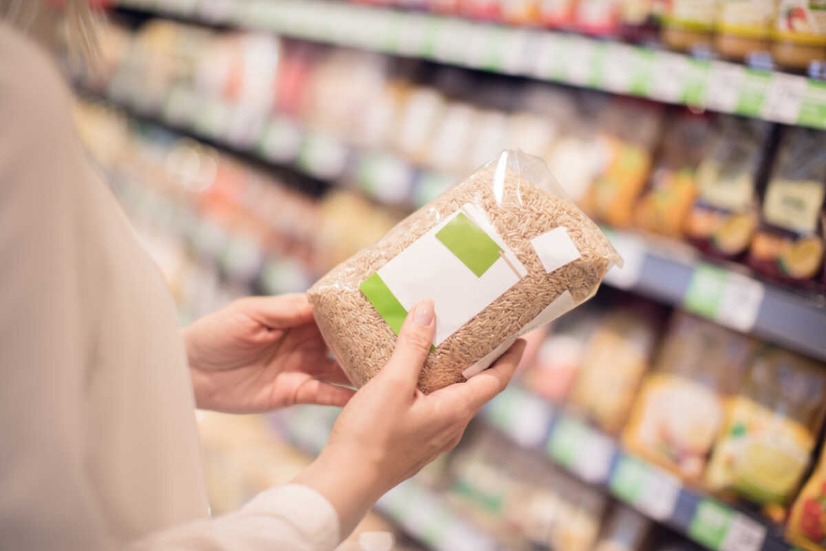 Unrecognizable buying organic rice in store, blank label