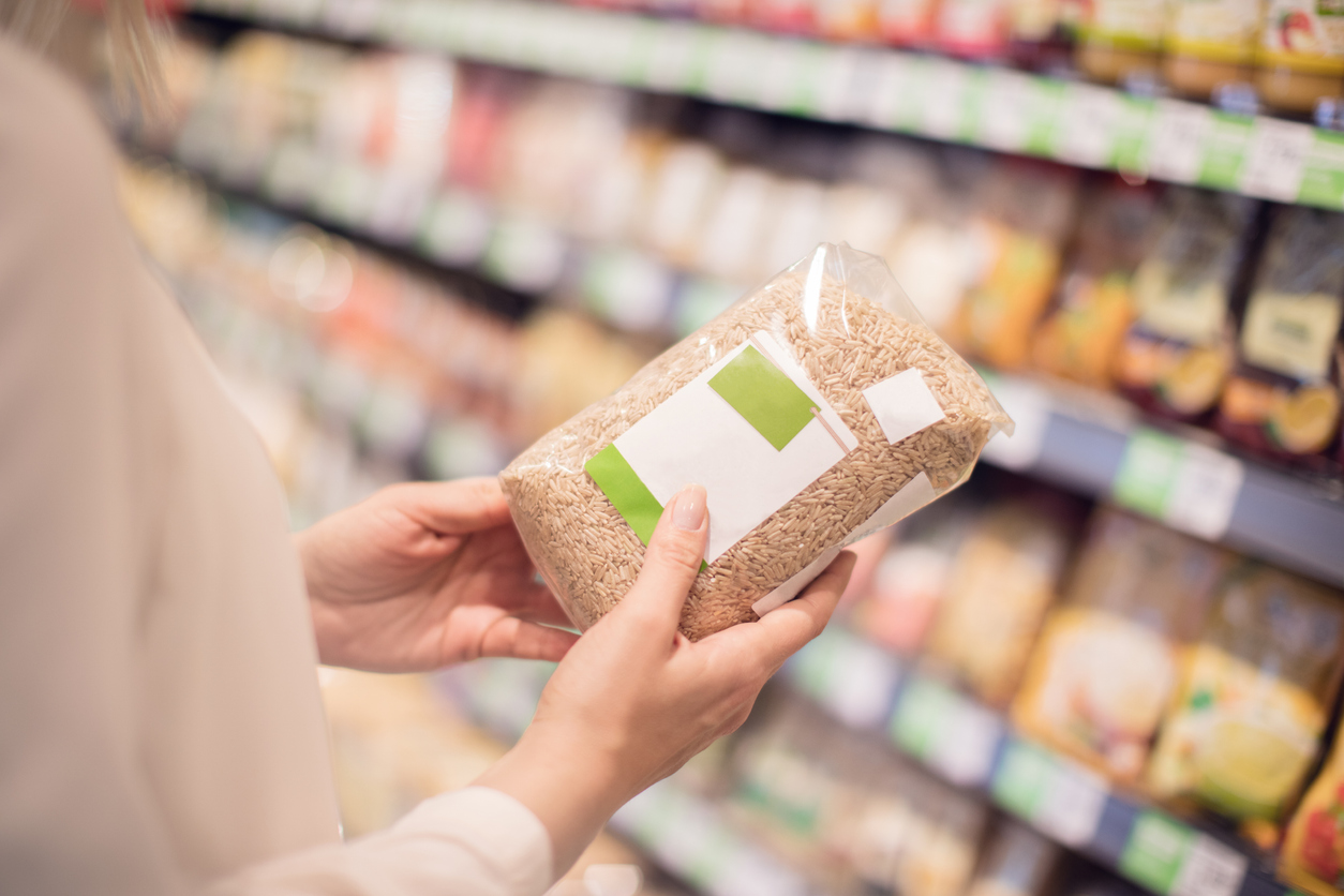 Unrecognizable buying organic rice in store, blank label
