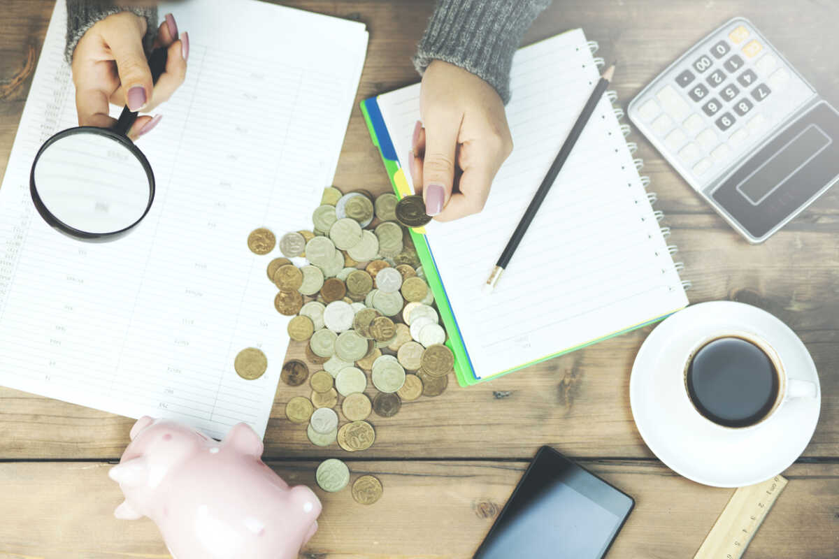 Financial concept, hand hold magnifying glass and coins