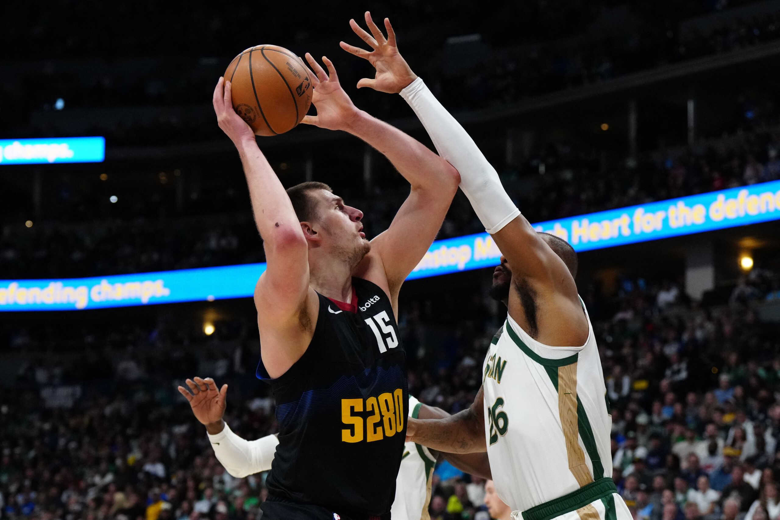 Mar 7, 2024; Denver, Colorado, USA; Boston Celtics forward Xavier Tillman (26) defends on Denver Nuggets center Nikola Jokic (15) in the first half at Ball Arena. Mandatory Credit: Ron Chenoy-USA TODAY Sports