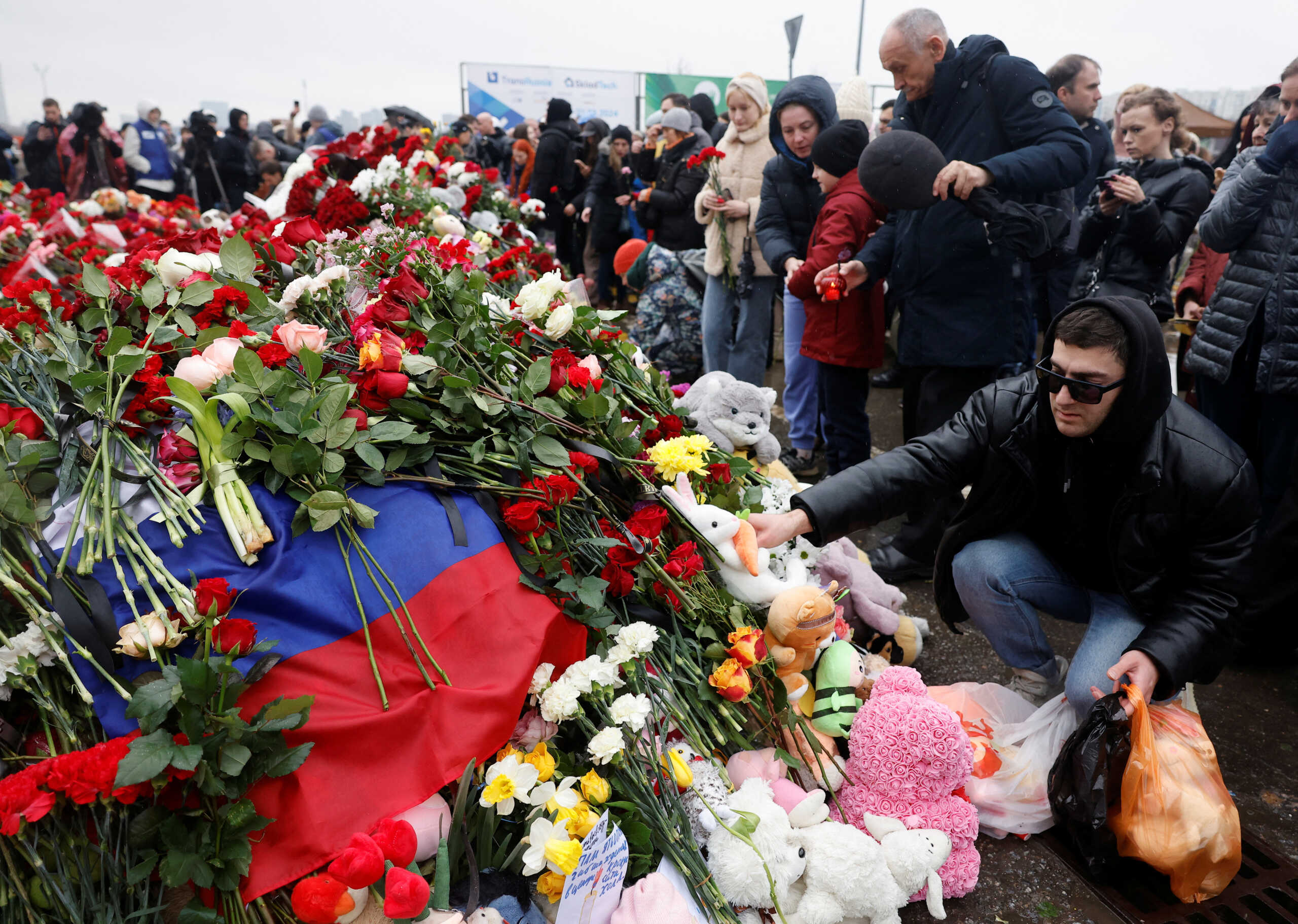 A man puts a toy at a makeshift memorial to the victims of a shooting attack set up outside the Crocus City Hall concert venue in the Moscow Region, Russia, March 24, 2024. REUTERS