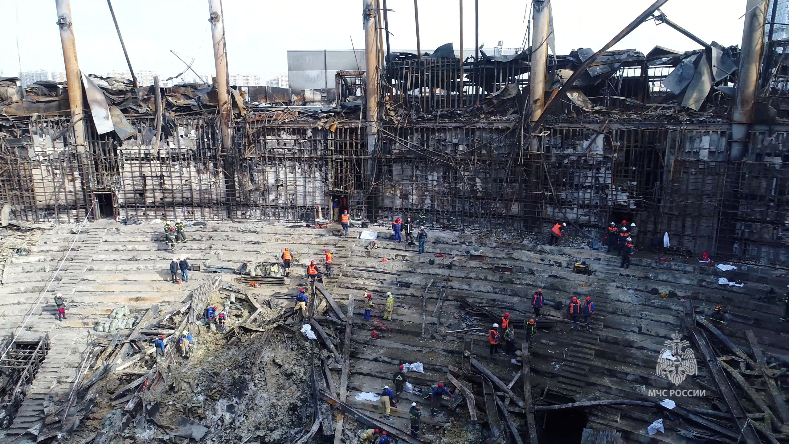 Members of the Russian Emergencies Ministry and workers remove debris inside the burnt-out Crocus City Hall following a deadly attack on the concert venue outside Moscow, Russia, in this still image taken from video released March 26, 2024. Russian Emergencies Ministry
