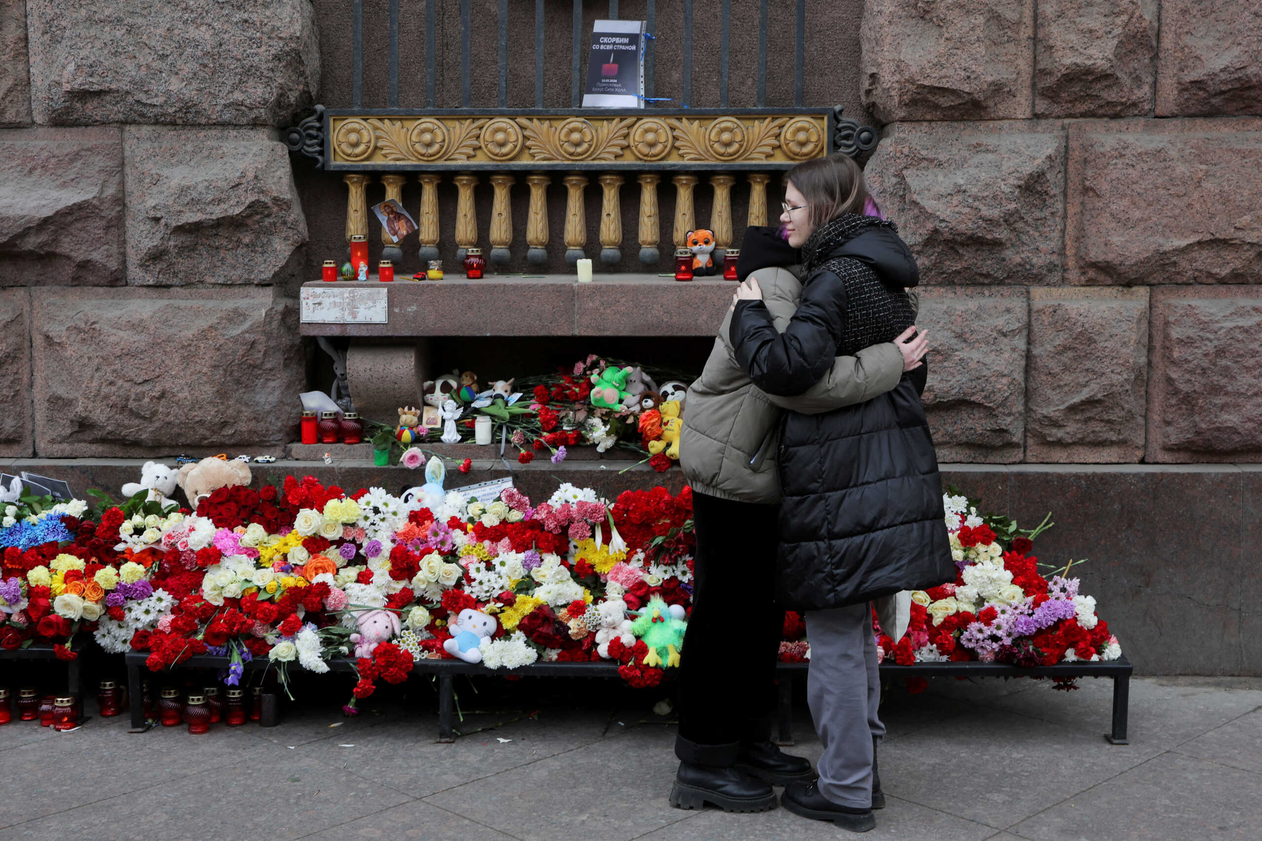 Women hug next to a makeshift memorial to the victims of a shooting attack at the Crocus City Hall concert venue in the Moscow Region, in Saint Petersburg, Russia March 24, 2024. REUTERS