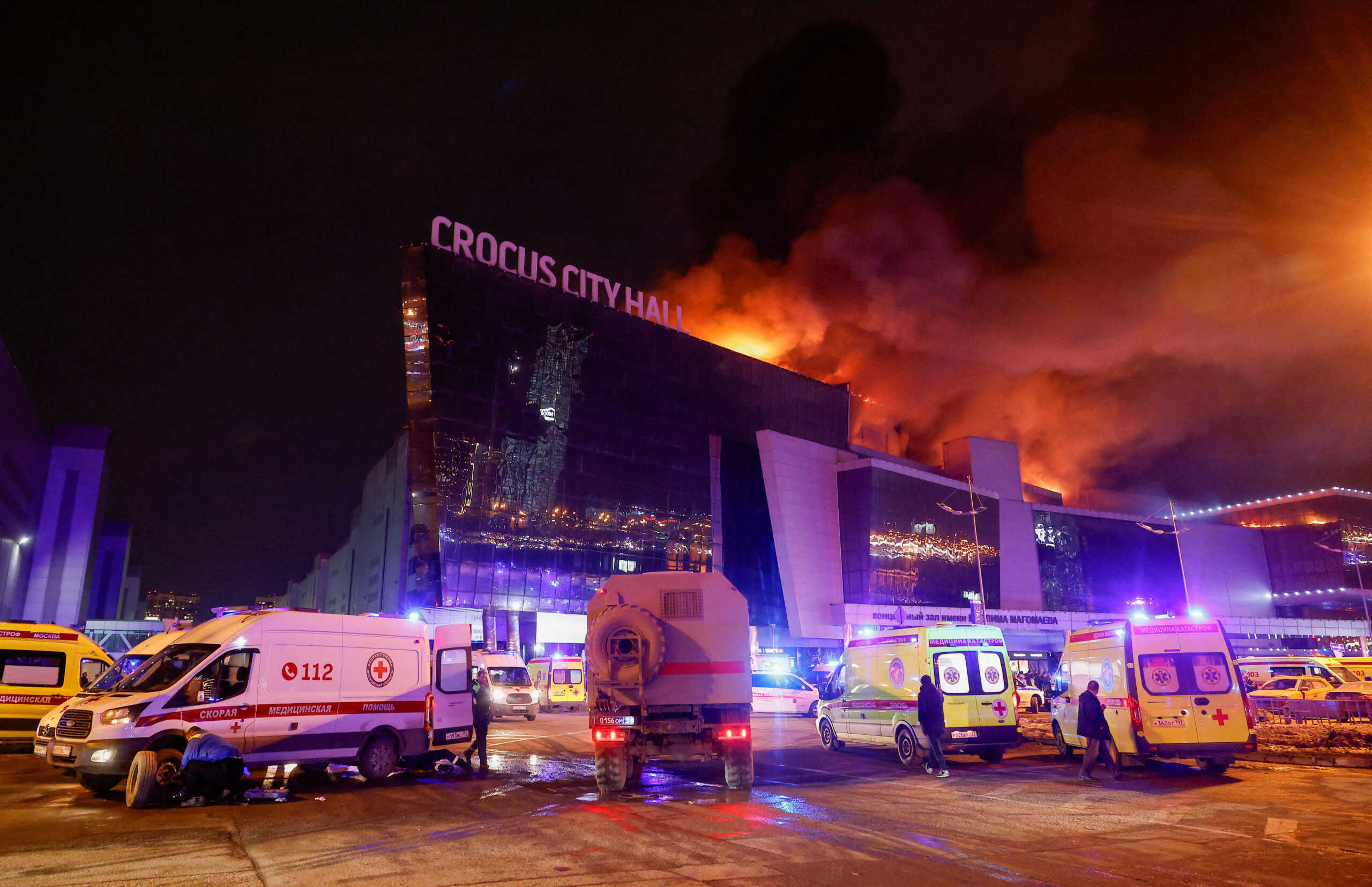 Vehicles of Russian emergency services are parked near the burning Crocus City Hall concert venue following a reported shooting incident, outside Moscow, Russia, March 22, 2024. REUTERS