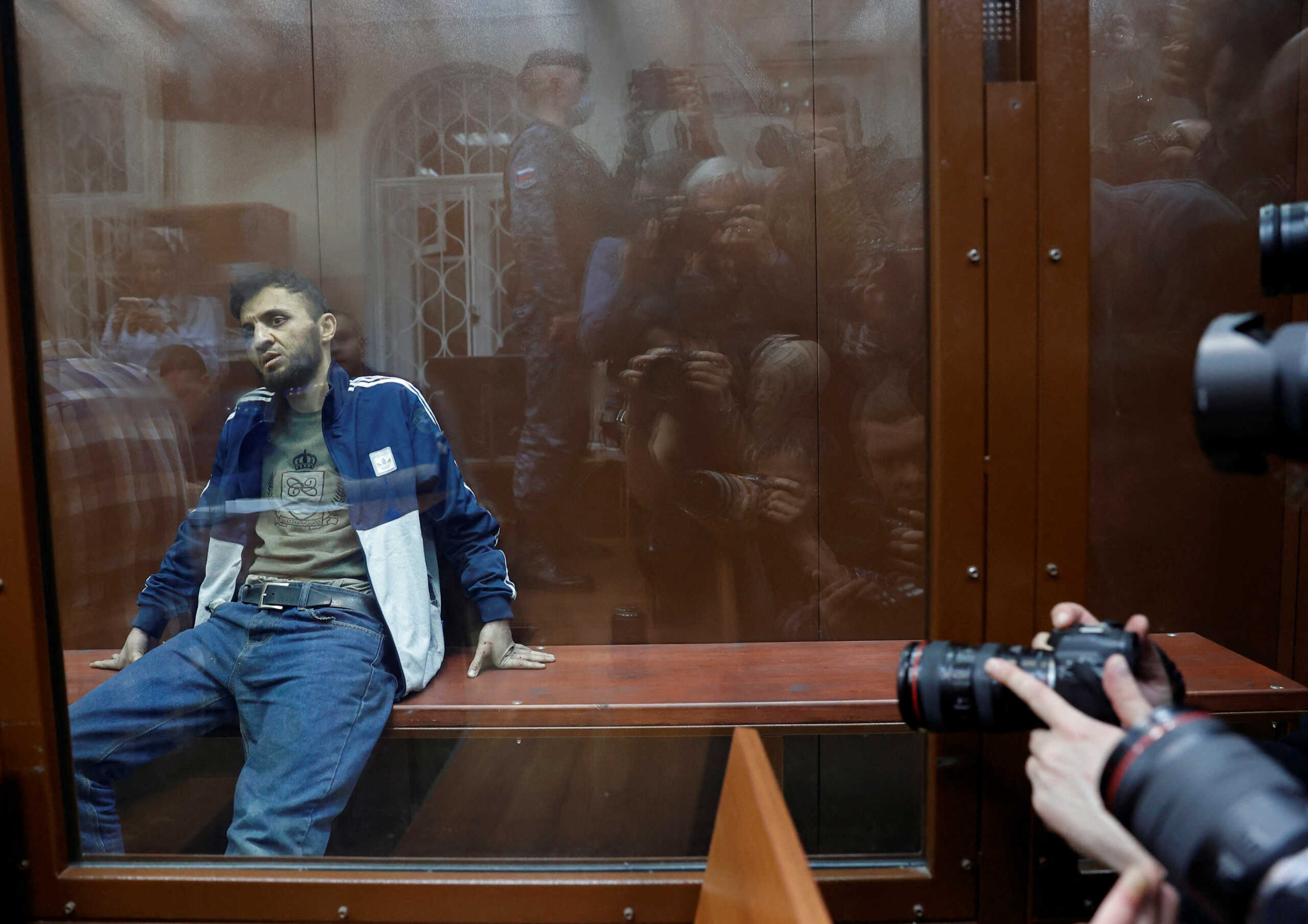 Dalerdzhon Mirzoyev, a suspect in the shooting attack at the Crocus City Hall concert venue, sits behind a glass wall of an enclosure for defendants at the Basmanny district court in Moscow, Russia March 24, 2024. REUTERS