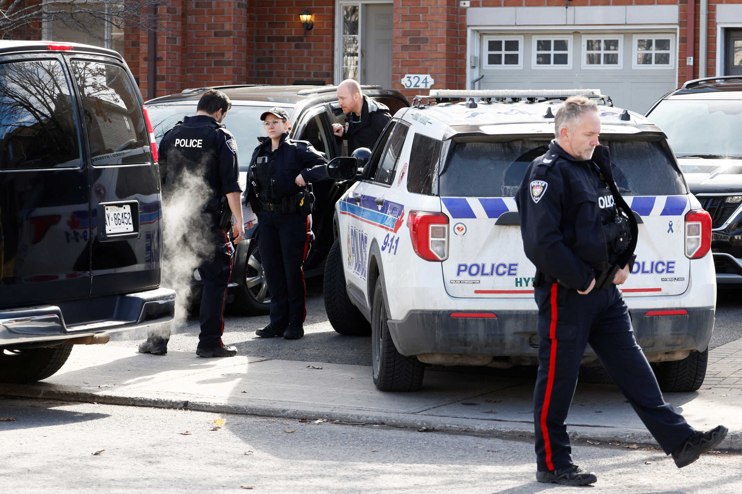 Ottawa Police Service officers surround a home after four children and two adults were found dead inside a neighbouring house in the Ottawa suburb of Barrhaven, Ontario, Canada March 7, 2024.  REUTERS