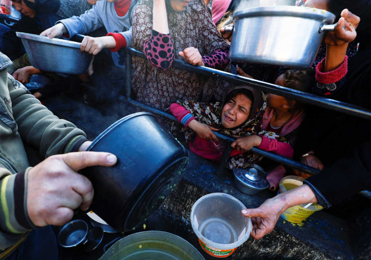 A child reacts as Palestinians wait to receive food during the Muslim holy fasting month of Ramadan, as the conflict between Israel and Hamas continues, in Rafah, in the southern Gaza Strip March 13, 2024. REUTERS