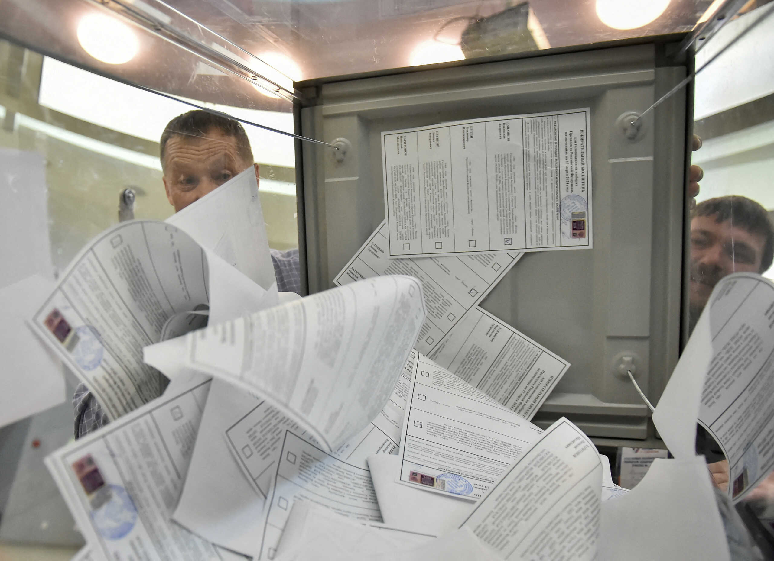 Members of an electoral commission empty a ballot box to count votes, after polling stations closed on the final day of the presidential election in Novosibirsk, Russia, March 17, 2024. REUTERS