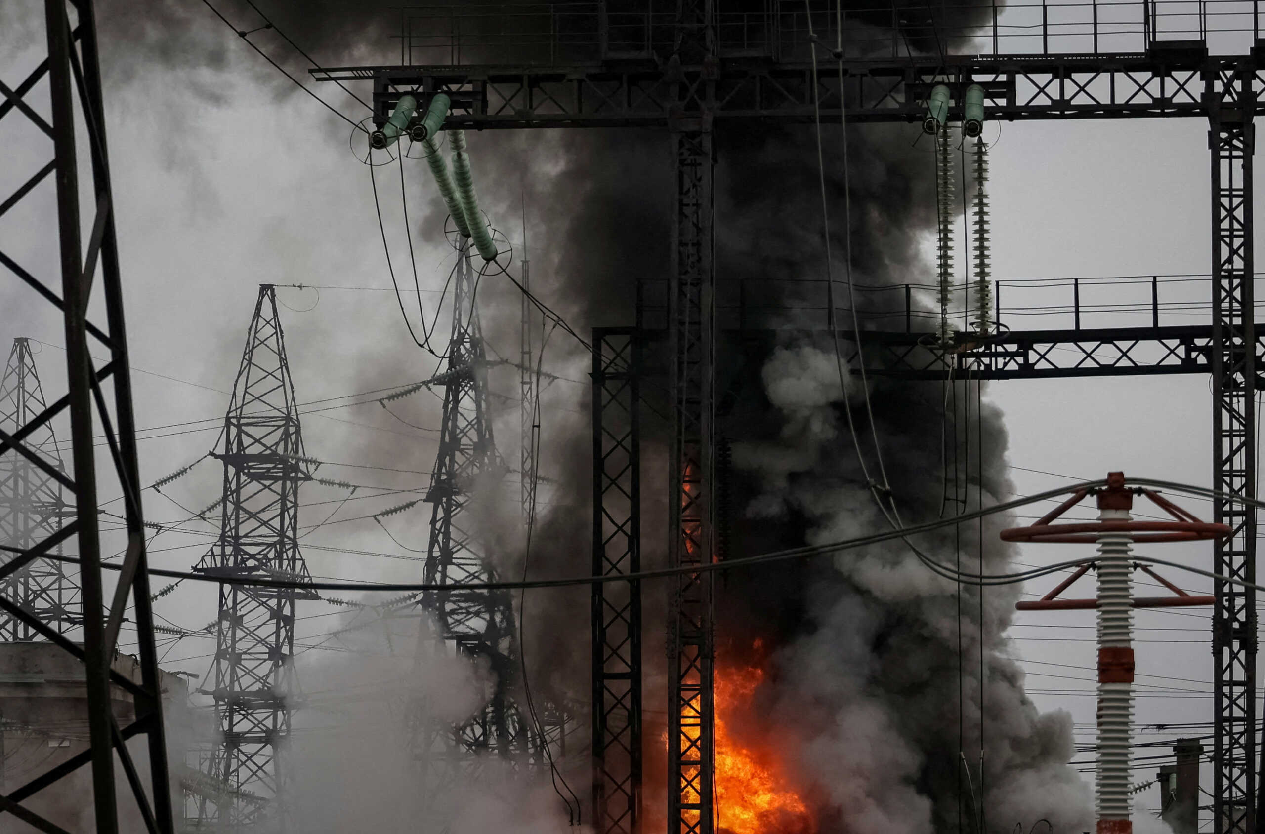 FILE PHOTO: Smoke and fire are seen near a high-voltage line at a site of a Russian missile strike, amid Russia's attack on Ukraine, outside Kharkiv, Ukraine March 22, 2024. REUTERS