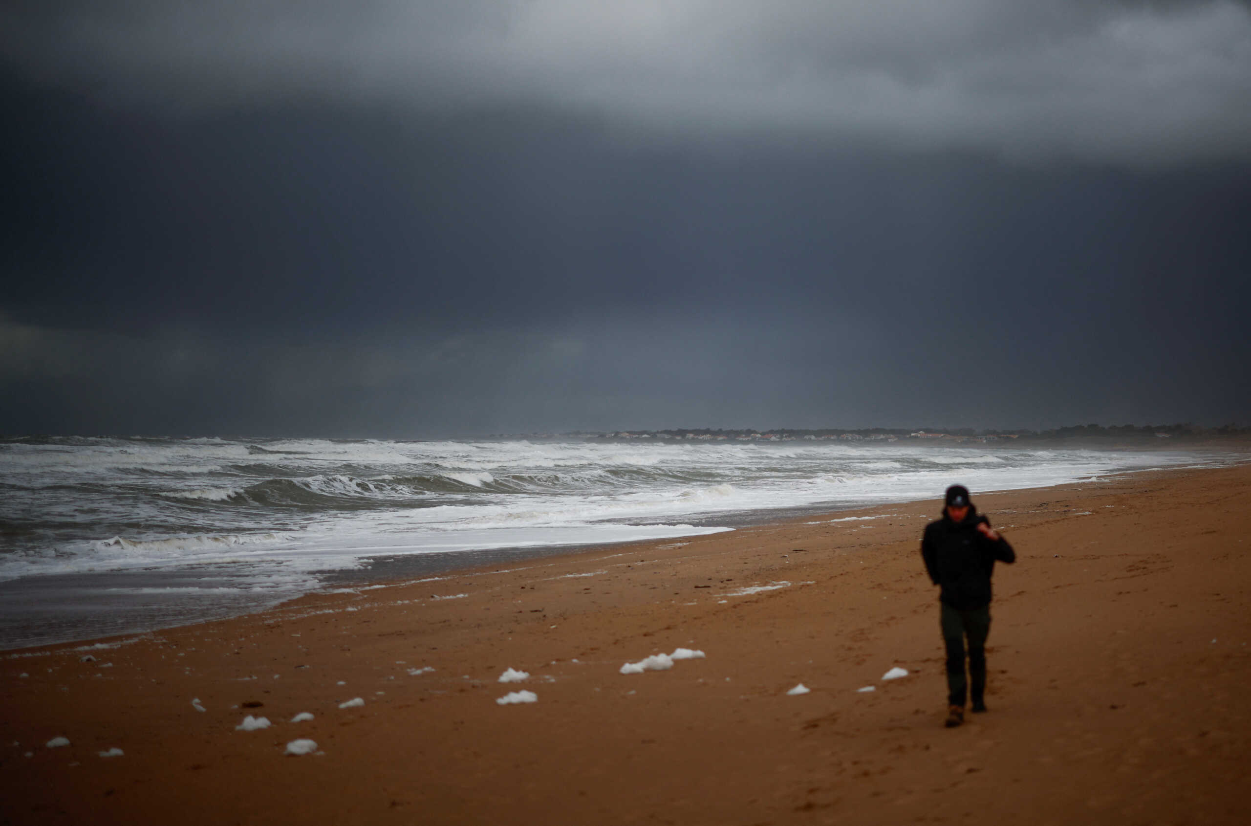 A man walks on a beach in Bretignolles-sur-Mer, France, March 5, 2024. REUTERS