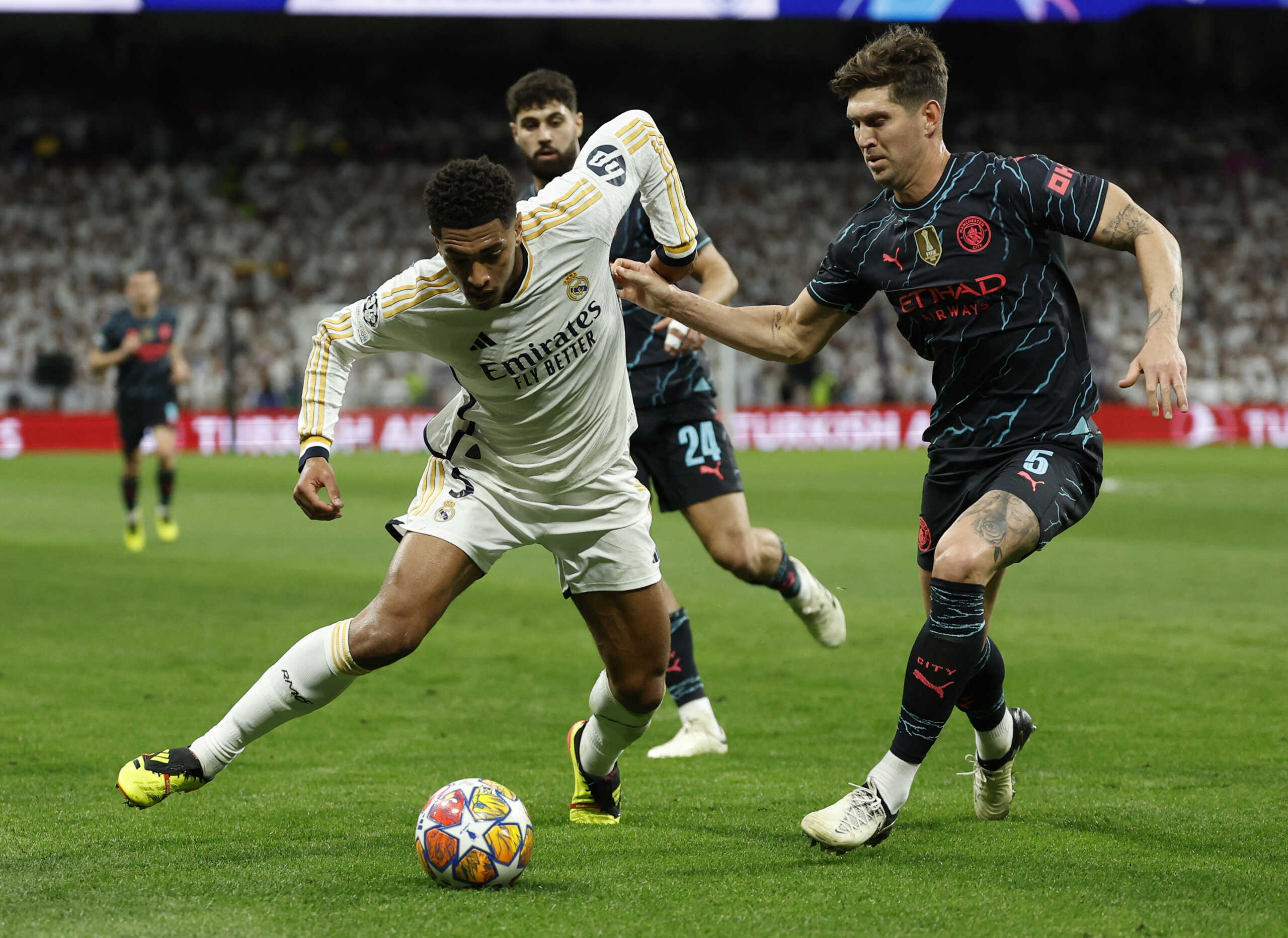 Soccer Football - Champions League - Quarter Final - First Leg - Real Madrid v Manchester City - Santiago Bernabeu, Madrid, Spain - April 9, 2024 Real Madrid's Jude Bellingham in action with Manchester City's John Stones REUTERS