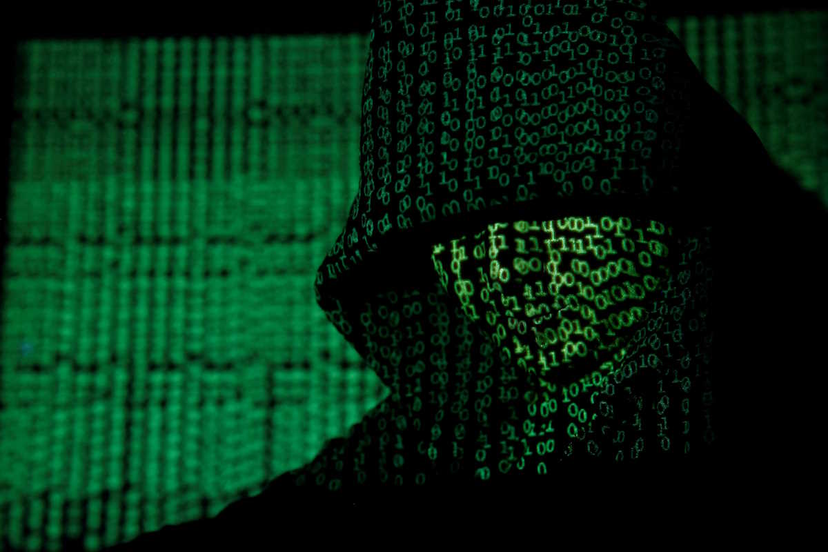 FILE PHOTO: A projection of cyber code on a hooded man is pictured in this illustration picture taken on May 13,  2017. Capitalizing on spying tools believed to have been developed by the U.S. National Security Agency, hackers staged a cyber assault with a self-spreading malware that has infected tens of thousands of computers in nearly 100 countries. REUTERS
