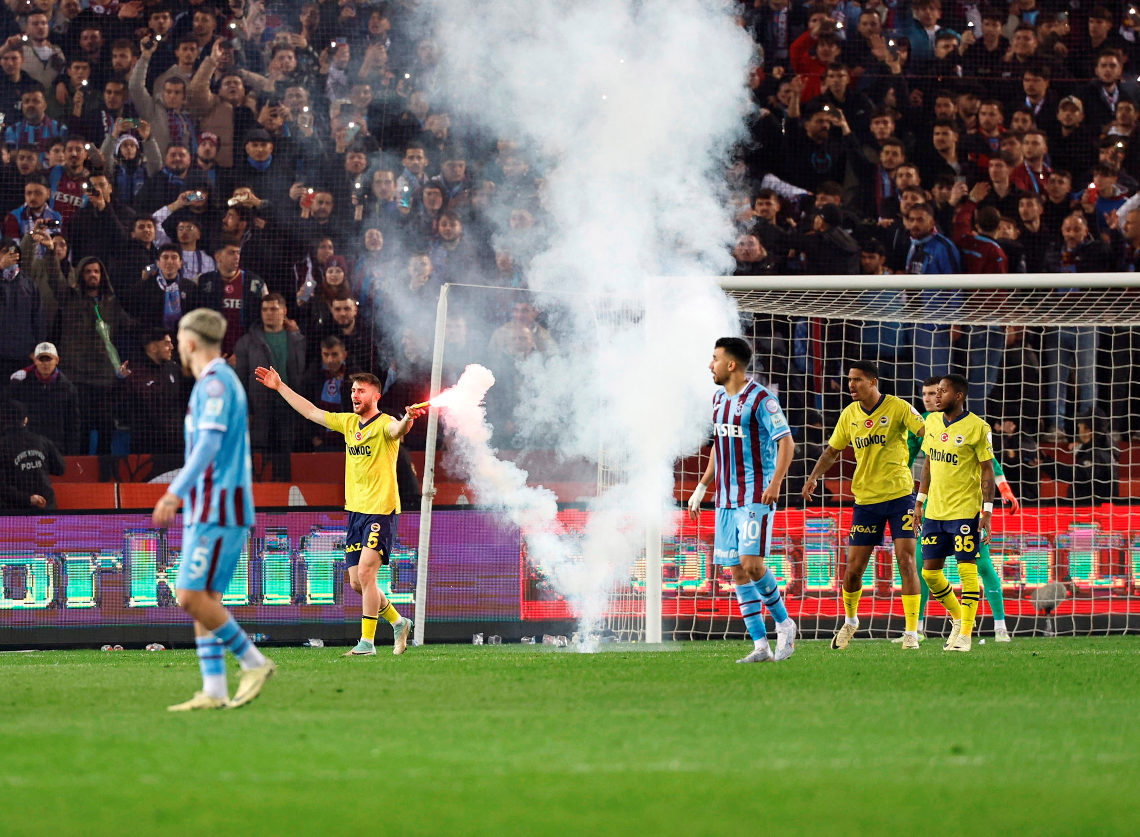 Soccer Football - Super Lig - Trabzonspor v Fenerbahce - Papara Park, Trabzon, Turkey - March 17, 2024 Fenerbahce's Ismail Yuksek holds a flare thrown by Trabzonspor fans. Fenerbahce.org