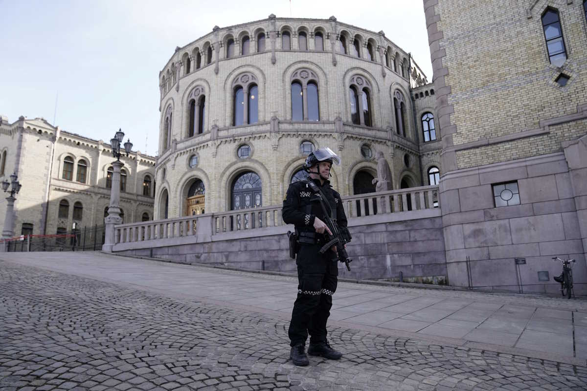 An armed police officer stands guard outside the Norwegian parliament after it received a bomb threat, in Oslo, Norway, April 3, 2024. Stian Lysberg Solum