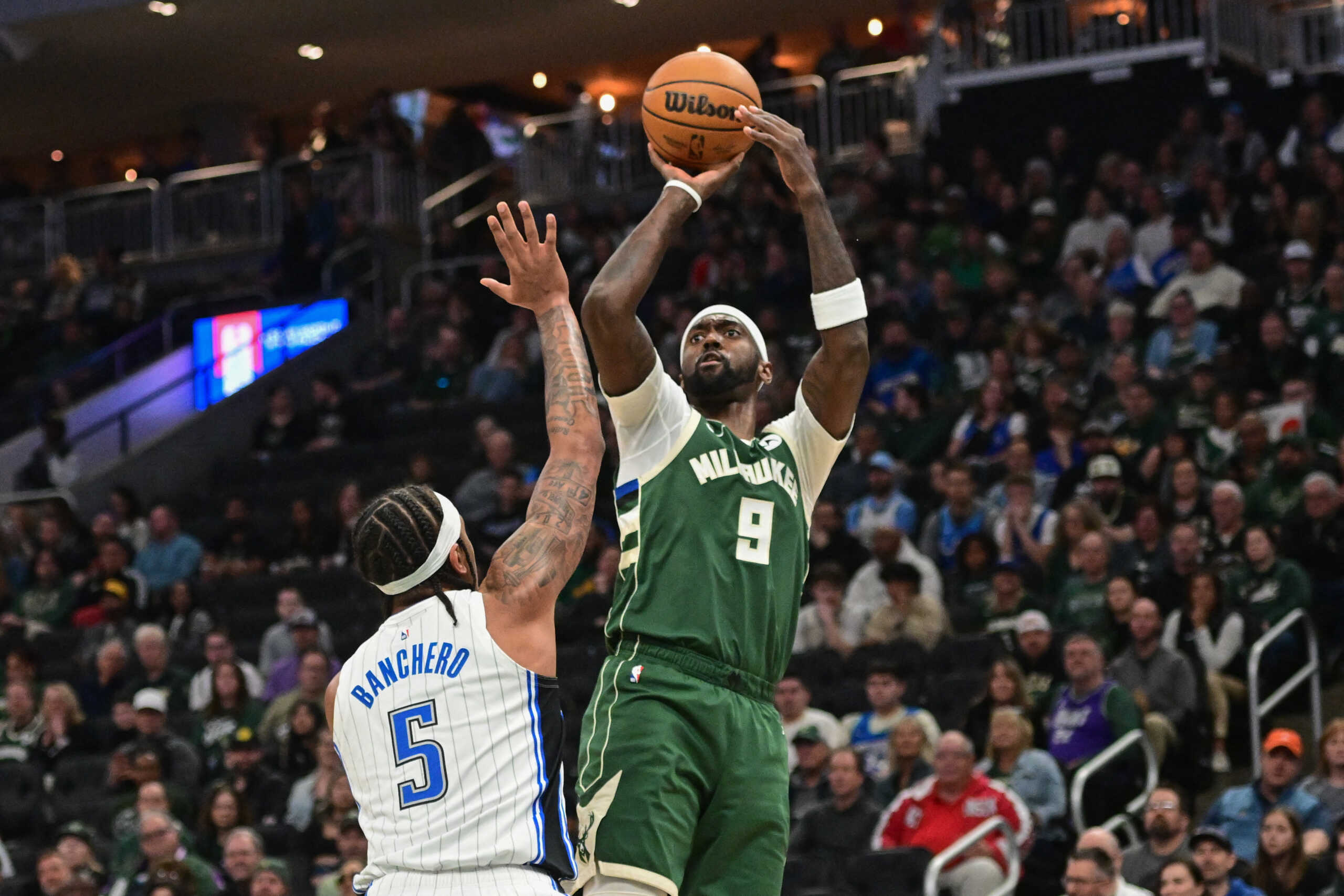 Apr 10, 2024; Milwaukee, Wisconsin, USA; Milwaukee Bucks guard Malik Beasley (5) takes a shot againstOrlando Magic forward Paolo Banchero (5) in the first quarter at Fiserv Forum. Mandatory Credit: Benny Sieu-USA TODAY Sports