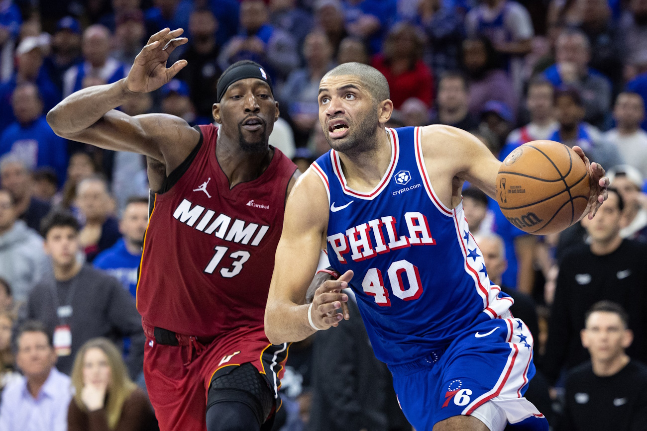 Apr 17, 2024; Philadelphia, Pennsylvania, USA; Philadelphia 76ers forward Nicolas Batum (40) drives past Miami Heat center Bam Adebayo (13) during the fourth quarter of a play-in game of the 2024 NBA playoffs at Wells Fargo Center. Mandatory Credit: Bill Streicher-USA TODAY Sports