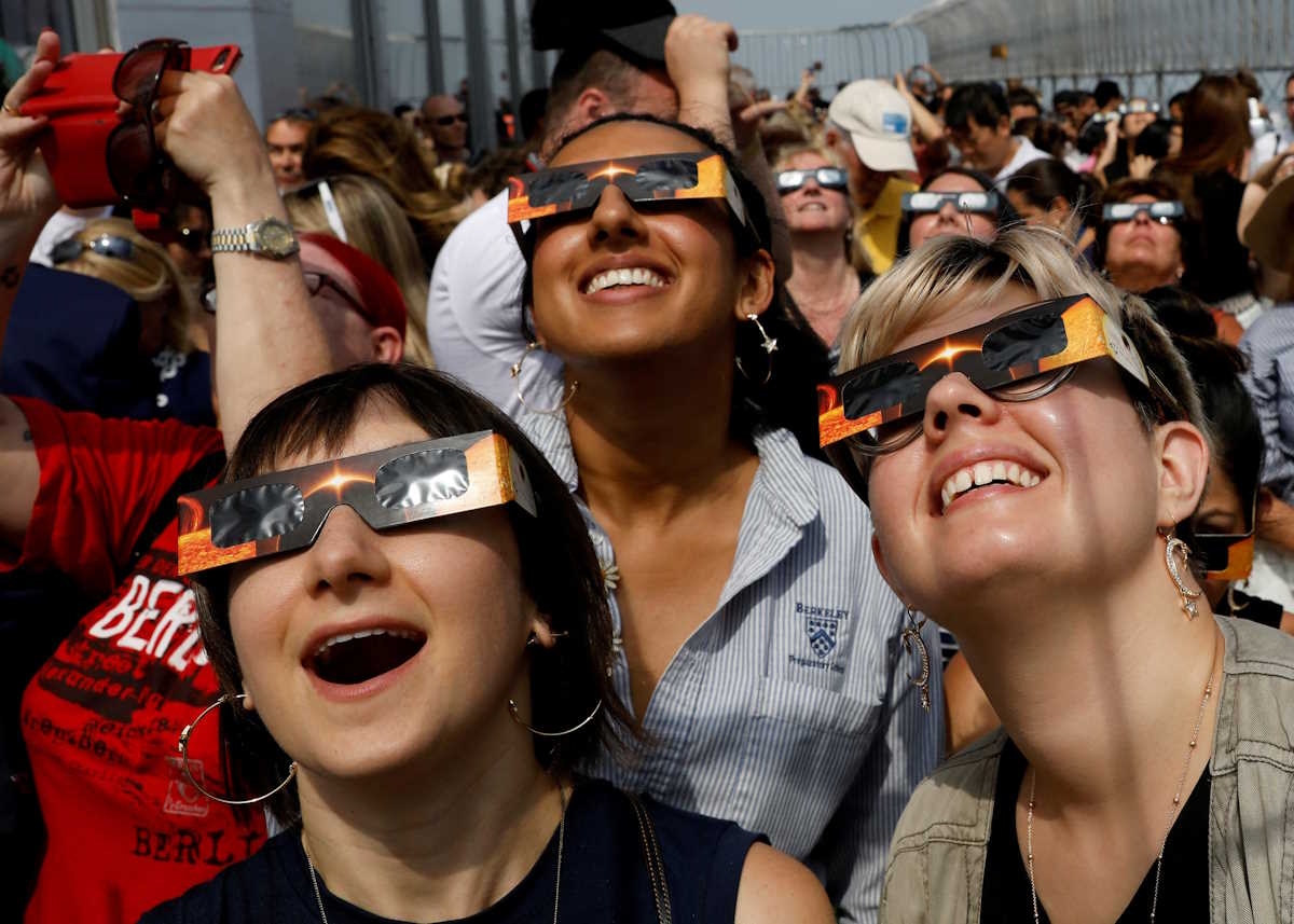 FILE PHOTO: People watch the solar eclipse from the observation deck of The Empire State Building in New York City, U.S., August 21, 2017.  Location coordinates for this image are 40?44'54" N 73?59'8" W.   REUTERS