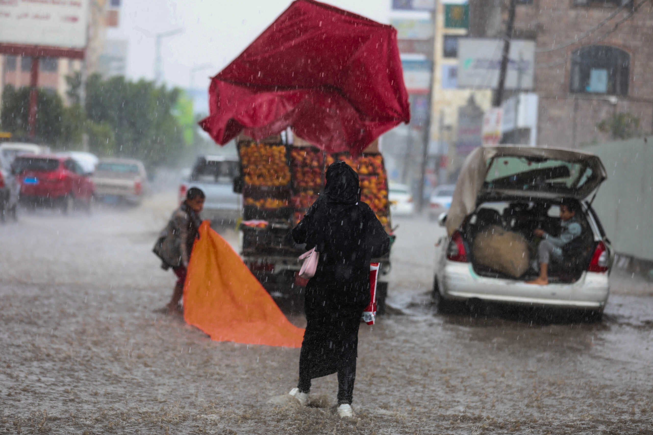 A woman walks down a flooded street during rains in Sanaa, Yemen, April 20, 2024. REUTERS