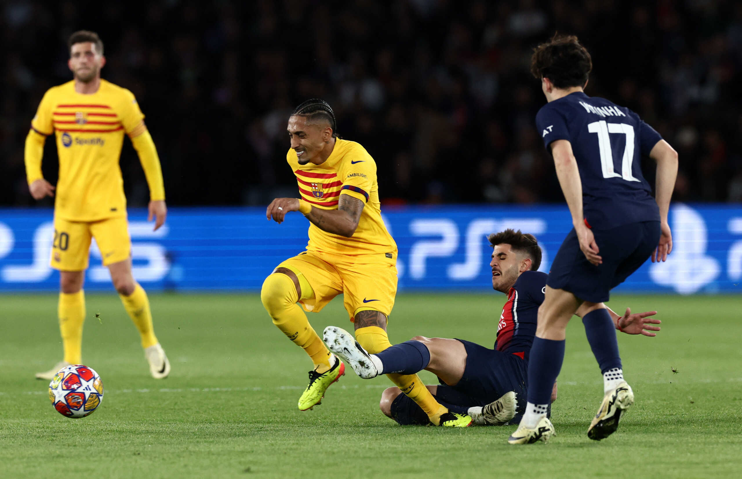 Soccer Football - Champions League - Quarter Final - First Leg - Paris St Germain v FC Barcelona - Parc des Princes, Paris, France - April 10, 2024 FC Barcelona's Raphinha in action with Paris St Germain's Lucas Beraldo and Vitinha REUTERS