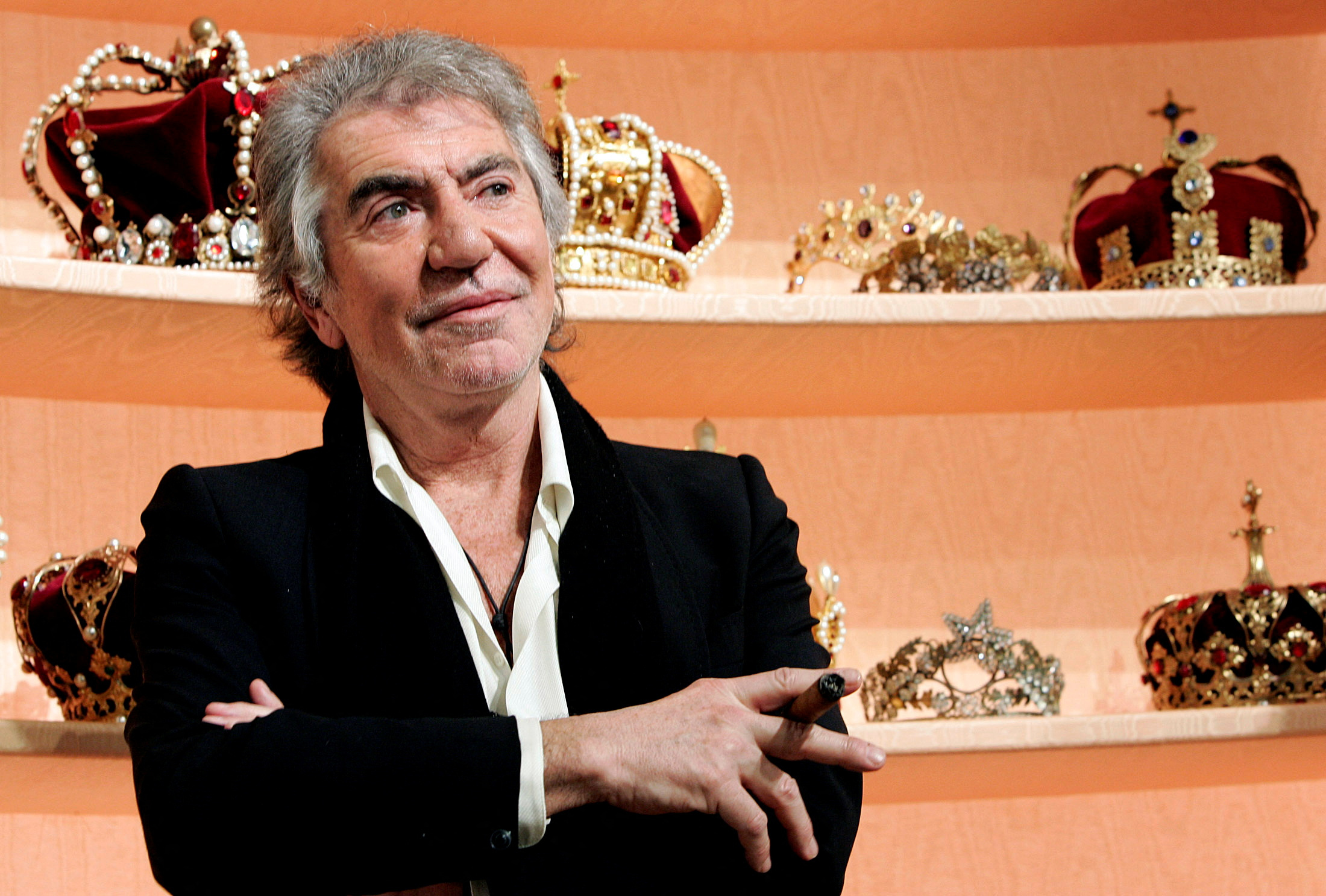 FILE PHOTO: Italian designer Roberto Cavalli smokes a cigar prior to the start his Fall