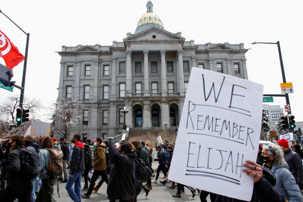 FILE PHOTO: A sign stating "We Remember Elijah" referencing Elijah McClain, is raised during a protest against the Brooklyn Center, Minnesota, police shooting of Daunte Wright, in Denver, Colorado, U.S., April 17, 2021.  REUTERS