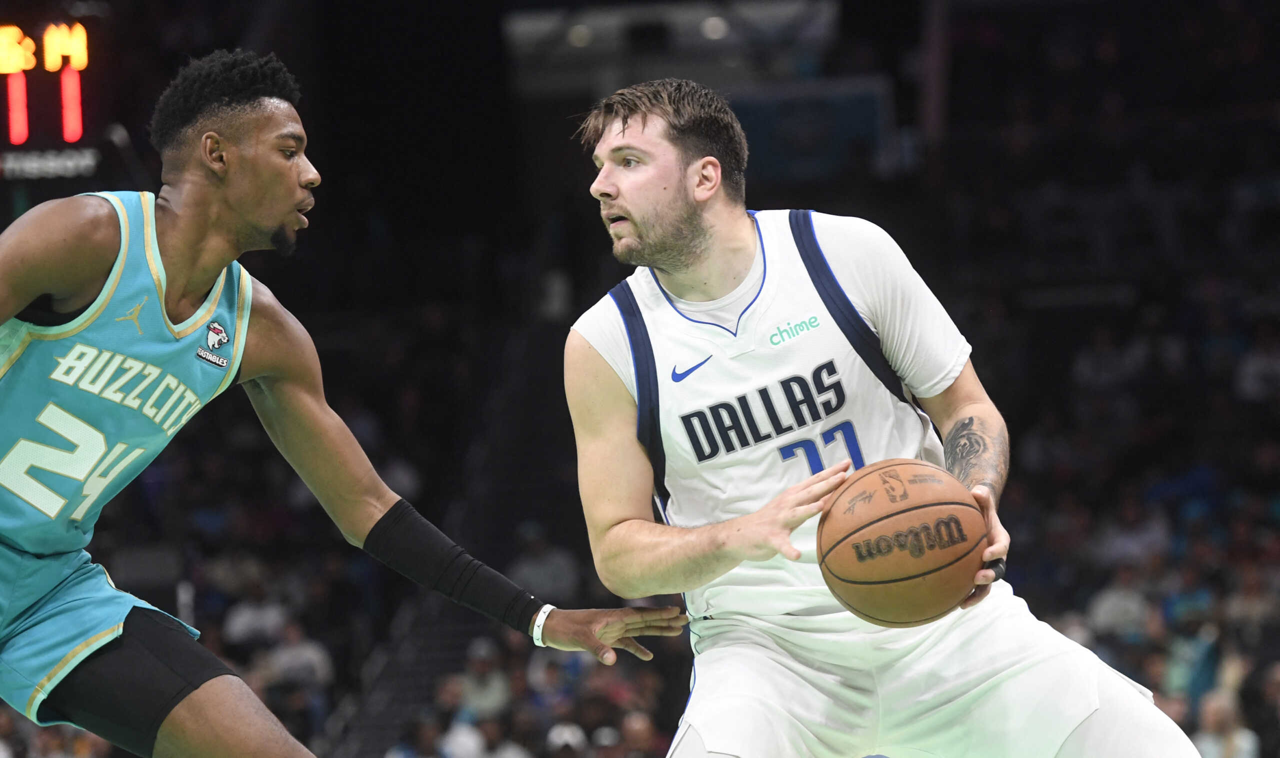 Apr 9, 2024; Charlotte, North Carolina, USA;  Dallas Mavericks guard Luka Doncic (77) looks to shoot while defended by Charlotte Hornets forward guard Brandon Miller (24) during the first half at the Spectrum Center. Mandatory Credit: Sam Sharpe-USA TODAY Sports