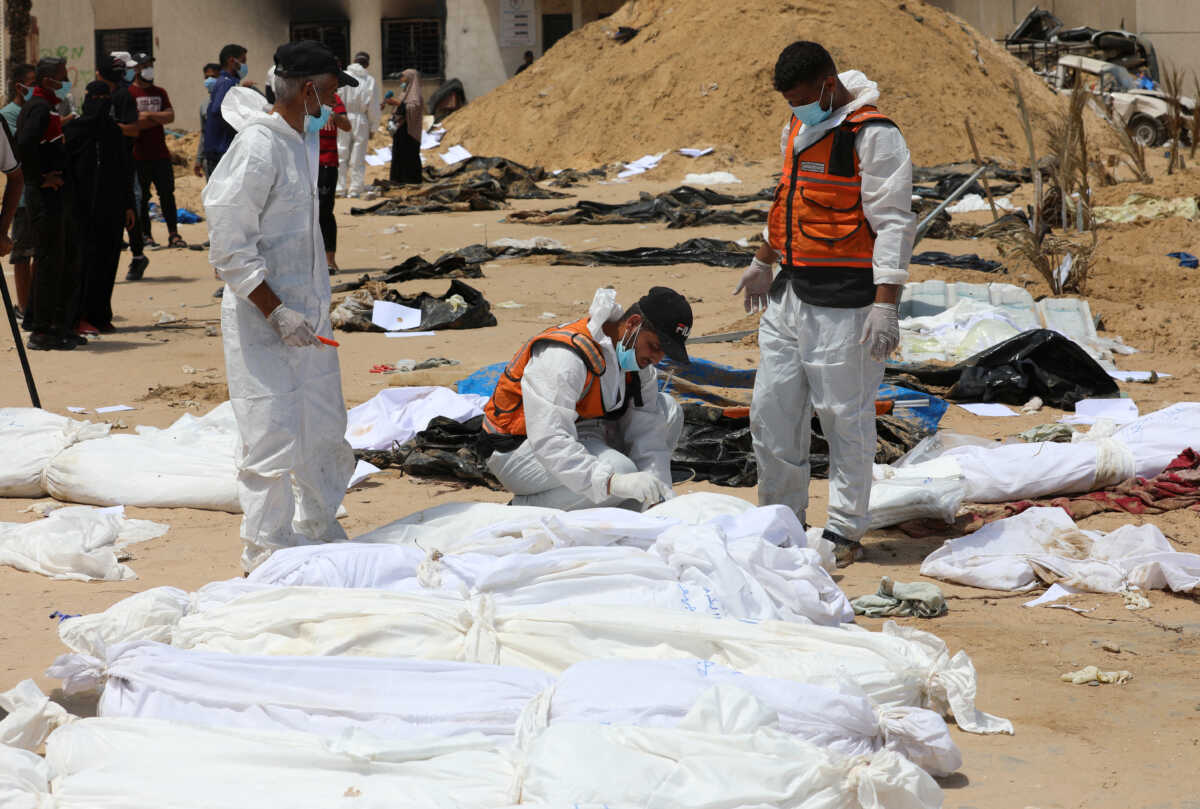 People work to move into a cemetery bodies of Palestinians killed during Israel's military offensive and buried at Nasser hospital, amid the ongoing conflict between Israel and the Palestinian Islamist group Hamas, in Khan Younis in the southern Gaza Strip, April 21, 2024. REUTERS