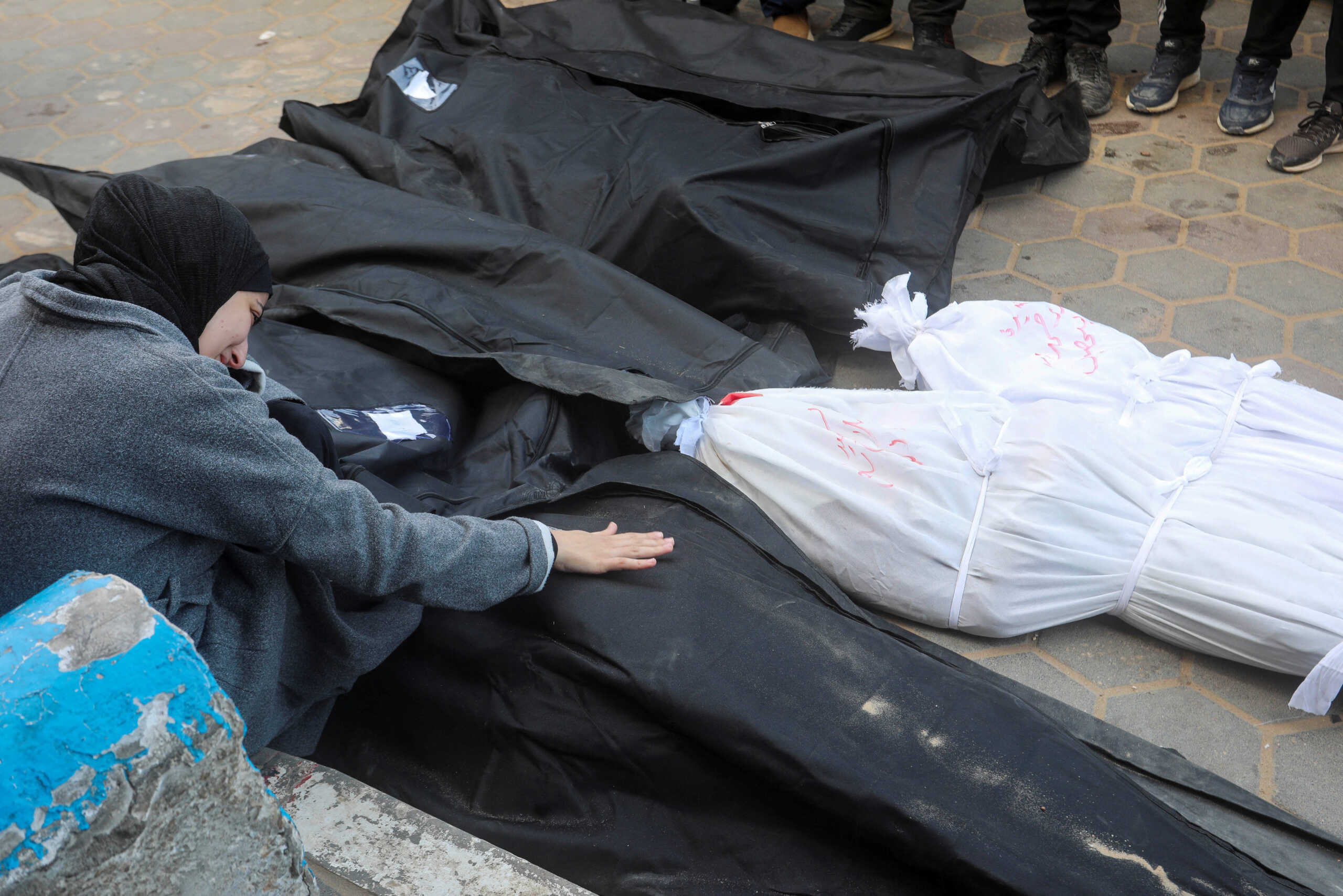 A Palestinian woman mourns next to the bodies of relatives killed in an Israeli strike, amid the ongoing conflict between Israel and Hamas, at Al-Aqsa hospital in Deir Al-Balah in the central Gaza Strip, March 25, 2024. REUTERS