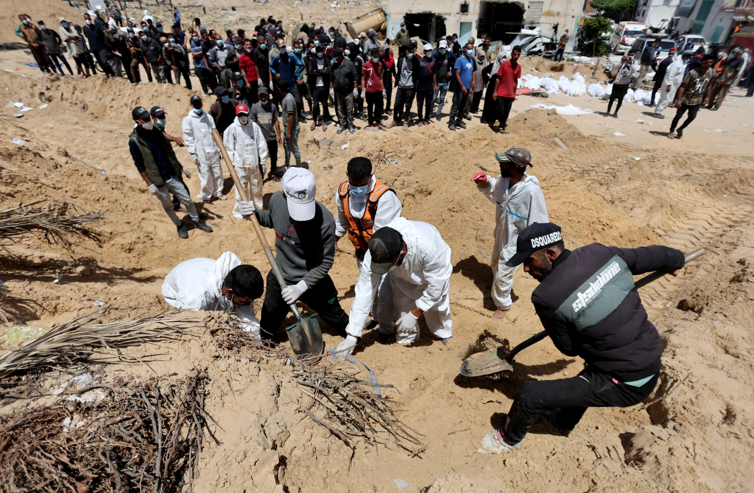 People work to move into a cemetery bodies of Palestinians killed during Israel's military offensive and buried at Nasser hospital, amid the ongoing conflict between Israel and the Palestinian Islamist group Hamas, in Khan Younis in the southern Gaza Strip, April 21, 2024. REUTERS