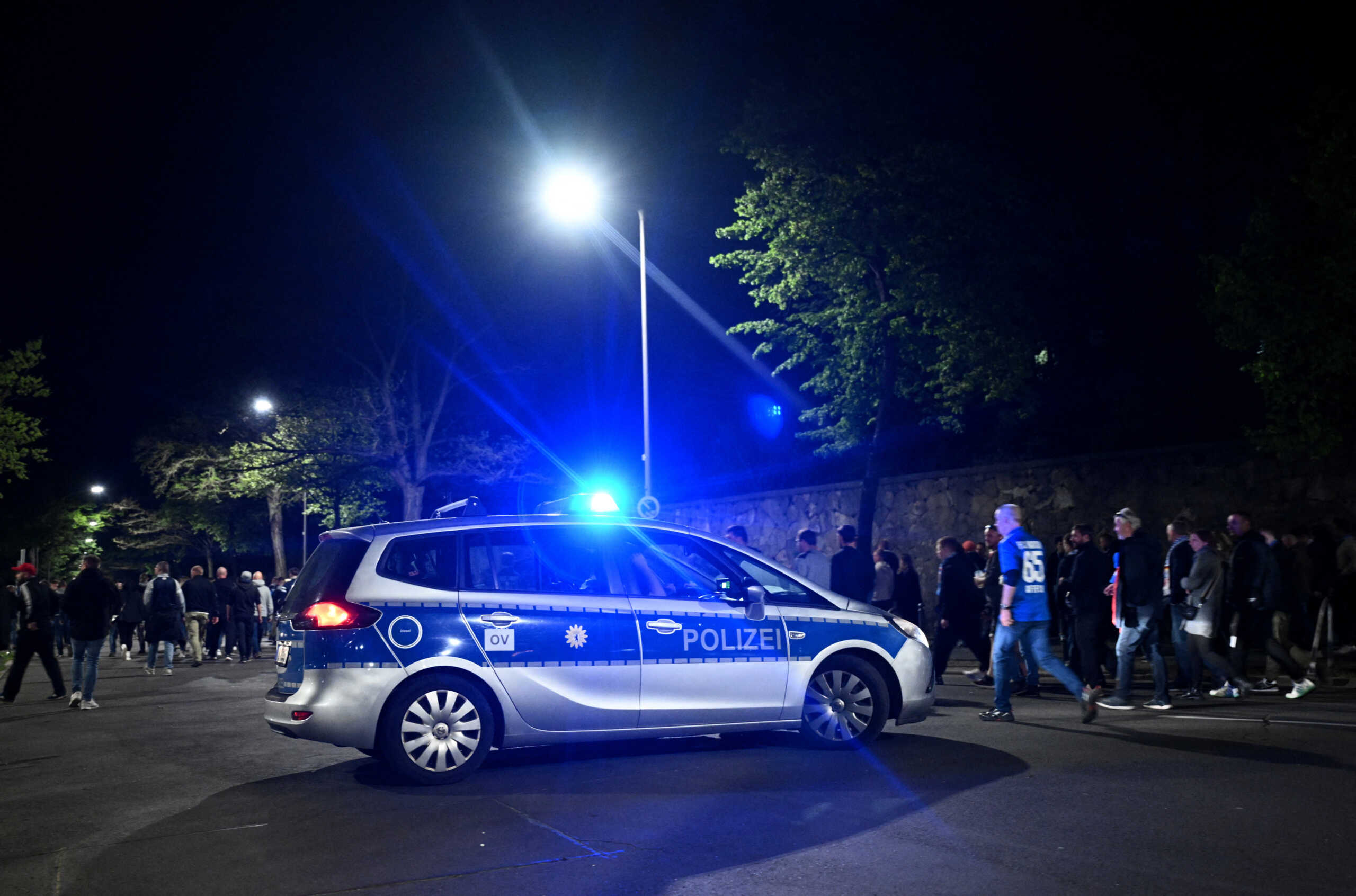 Soccer Football - Bundesliga 2 - Hertha BSC v Hansa Rostock - Olympiastadion, Berlin, Germany - April 12, 2024 Fans walk past a police car as they leave the stadium after the match, as the game is held under increased security measures amid a pending decision by BVG, Bundesverfassungsgericht, Germany’s Highest Court on whether german DFL Bundesliga clubs will have to pay police costs for riot police. REUTERS