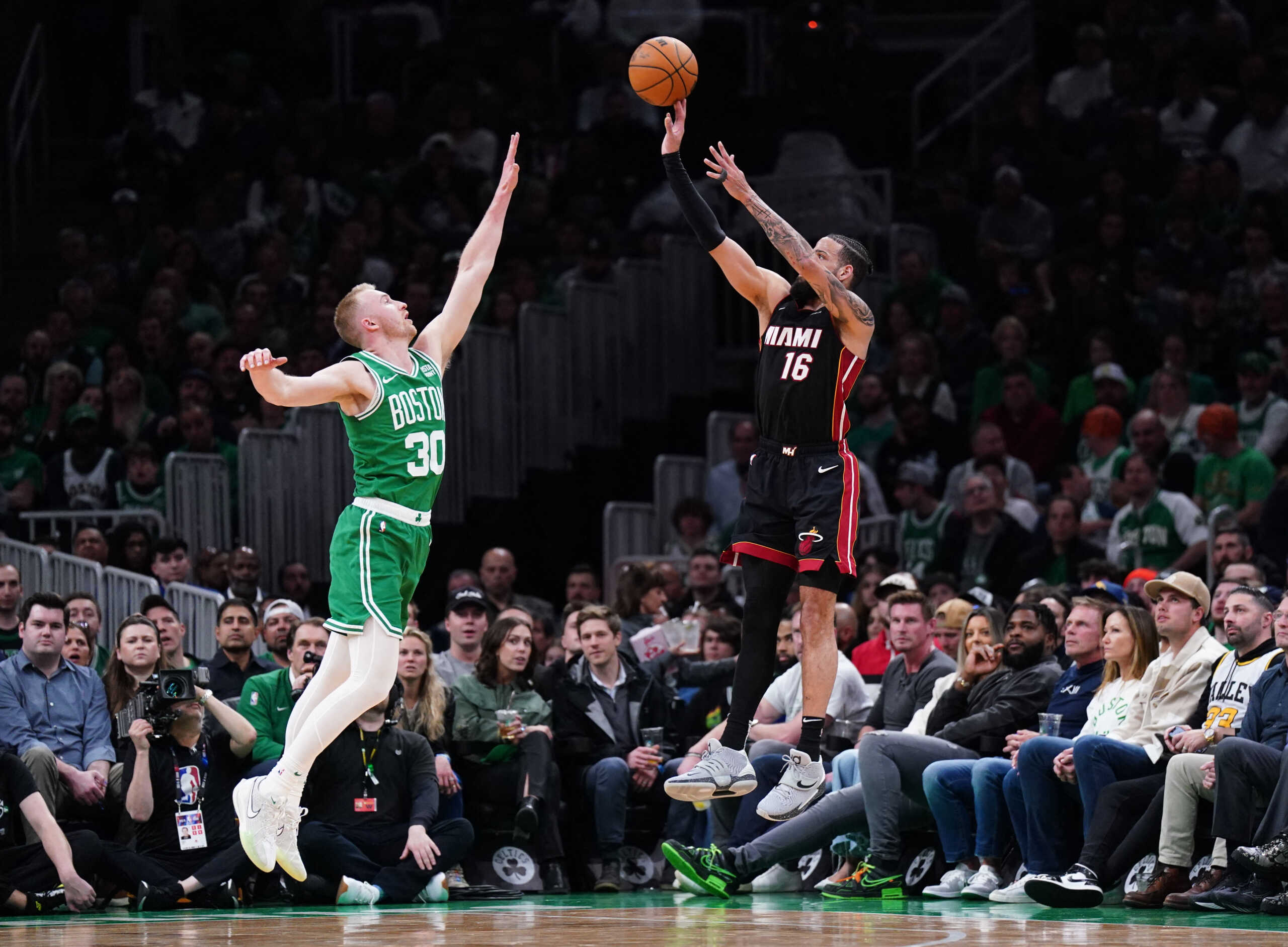 Apr 24, 2024; Boston, Massachusetts, USA; Miami Heat forward Caleb Martin (16) shoots for three points against Boston Celtics forward Sam Hauser (30) in the second quarter during game two of the first round for the 2024 NBA playoffs at TD Garden. Mandatory Credit: David Butler II-USA TODAY Sports