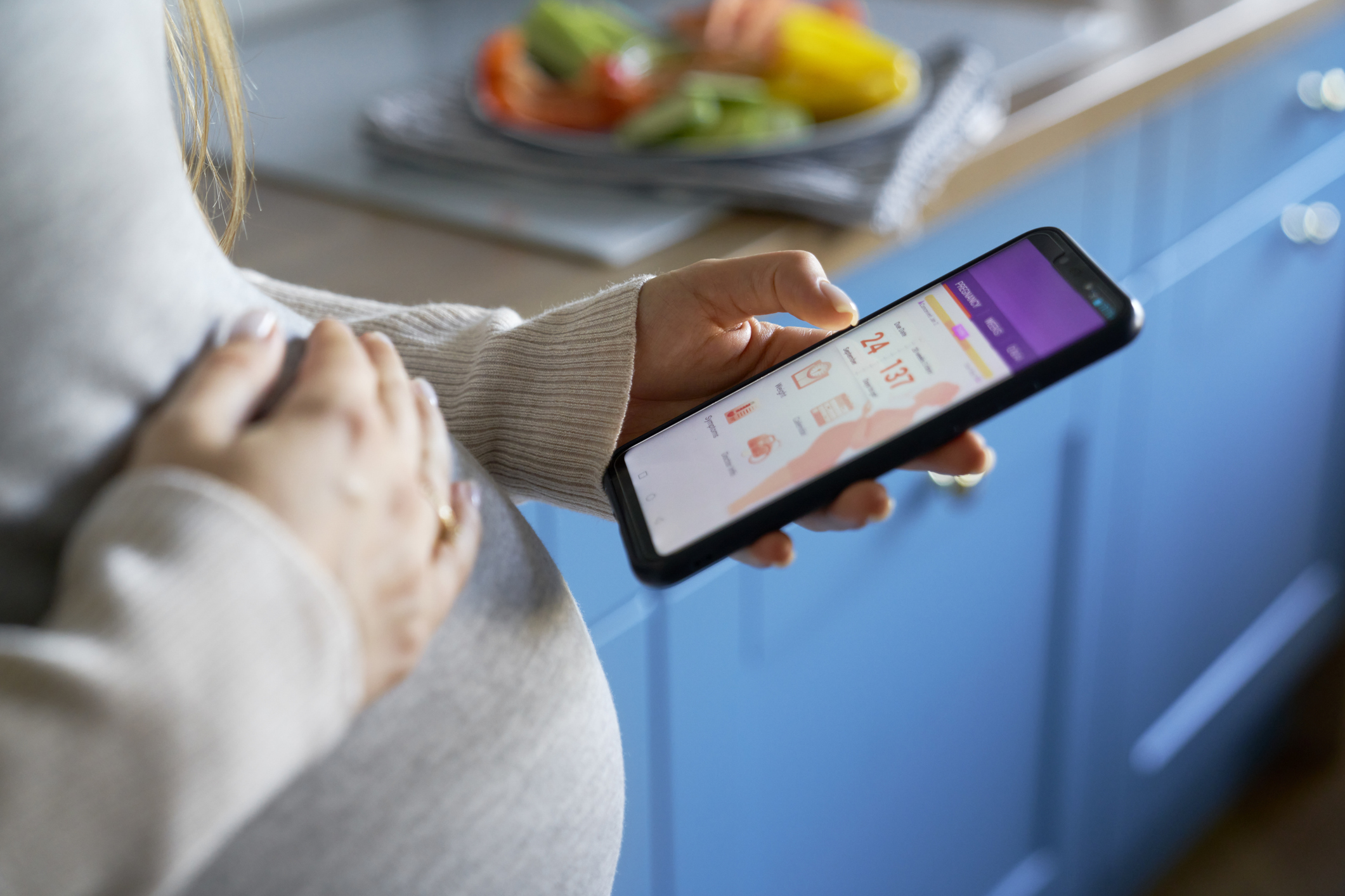 Pregnant woman using mobile app on smartphone