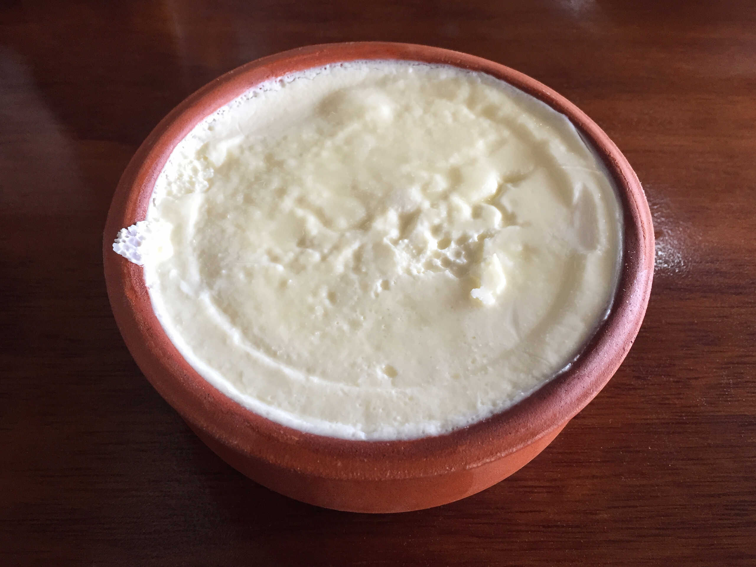Yoghurt in the clay pot on the table