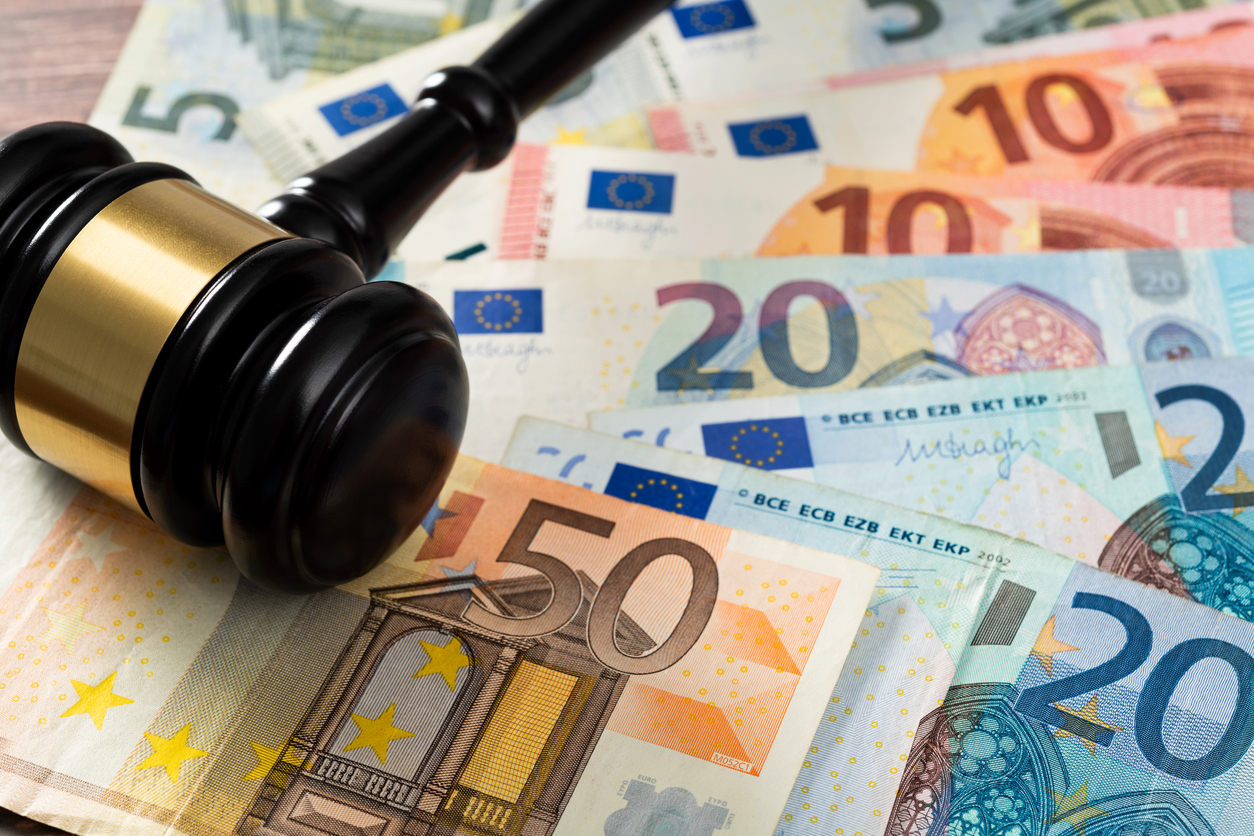 Gavel and stack European Union currency on the table.