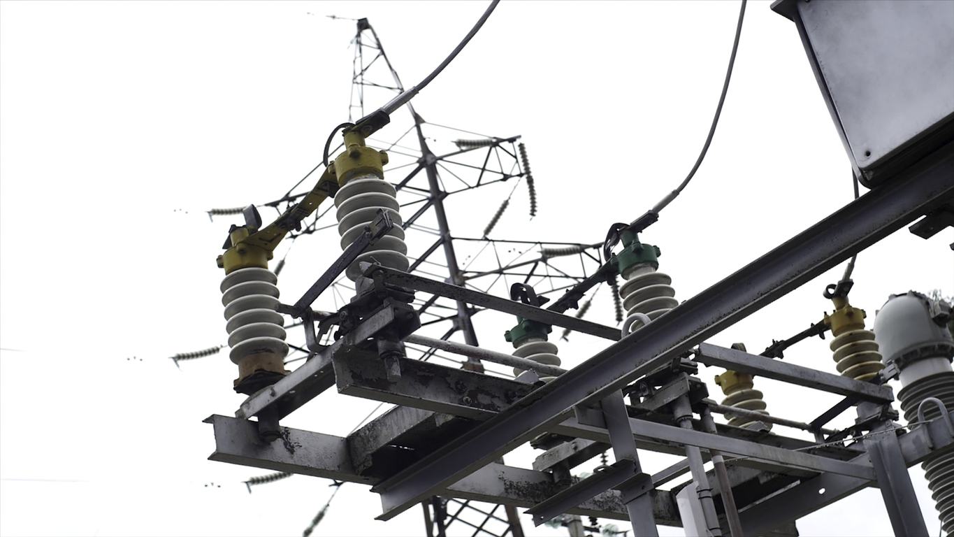 Electrical substation equipment: electricity transmission line, earthing switch. Earthing switch and a power line on sky background.