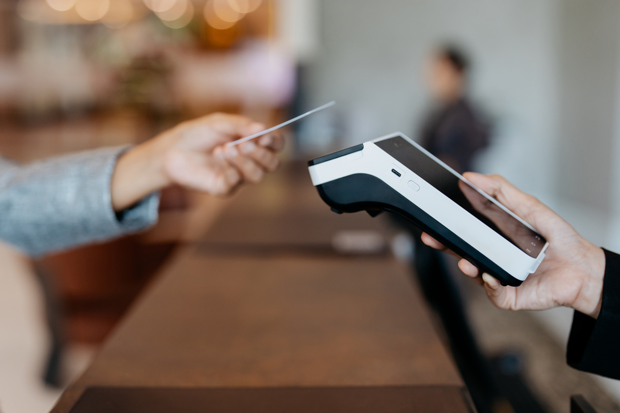 Businesswoman making payment with credit card at hotel reception. Credit card contactless payment concept.