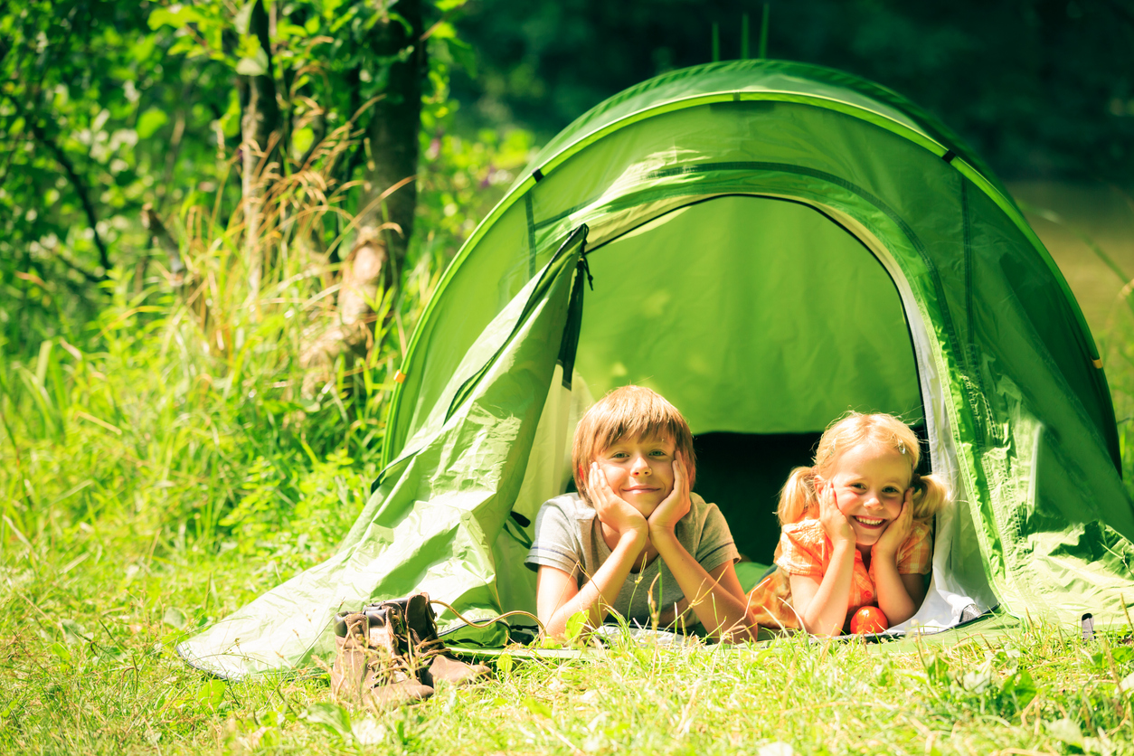 brother and sister are lying inside their tent