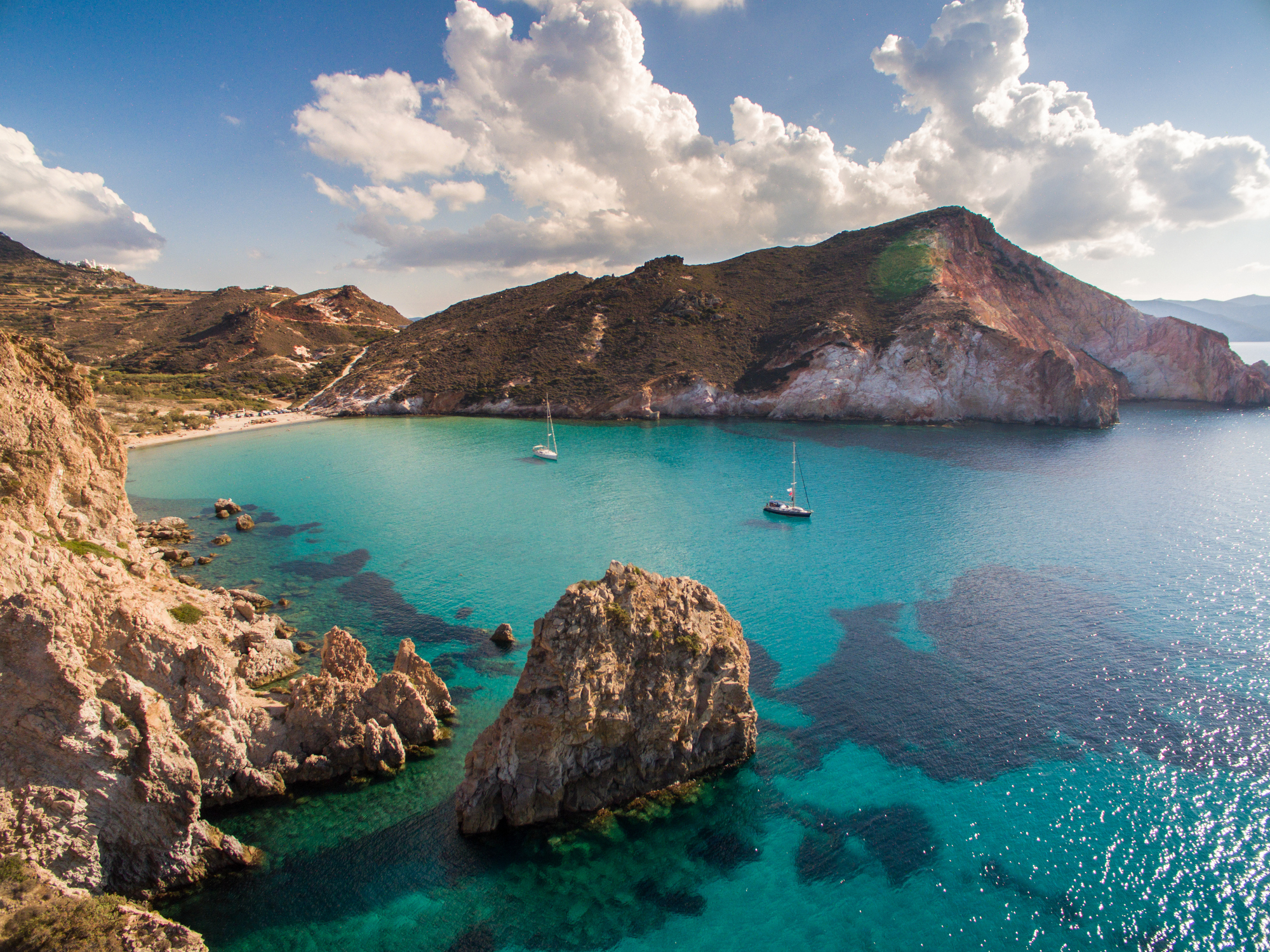 Crystal clear water in calm bay of Milos island is very attractive for sailboats and yachts