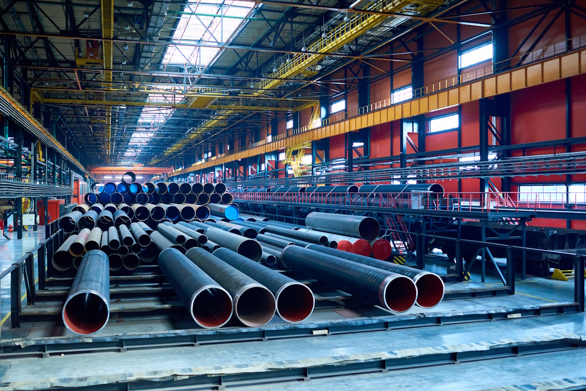 Abundance of tubes used for oil and gas industry placed in factory warehouse