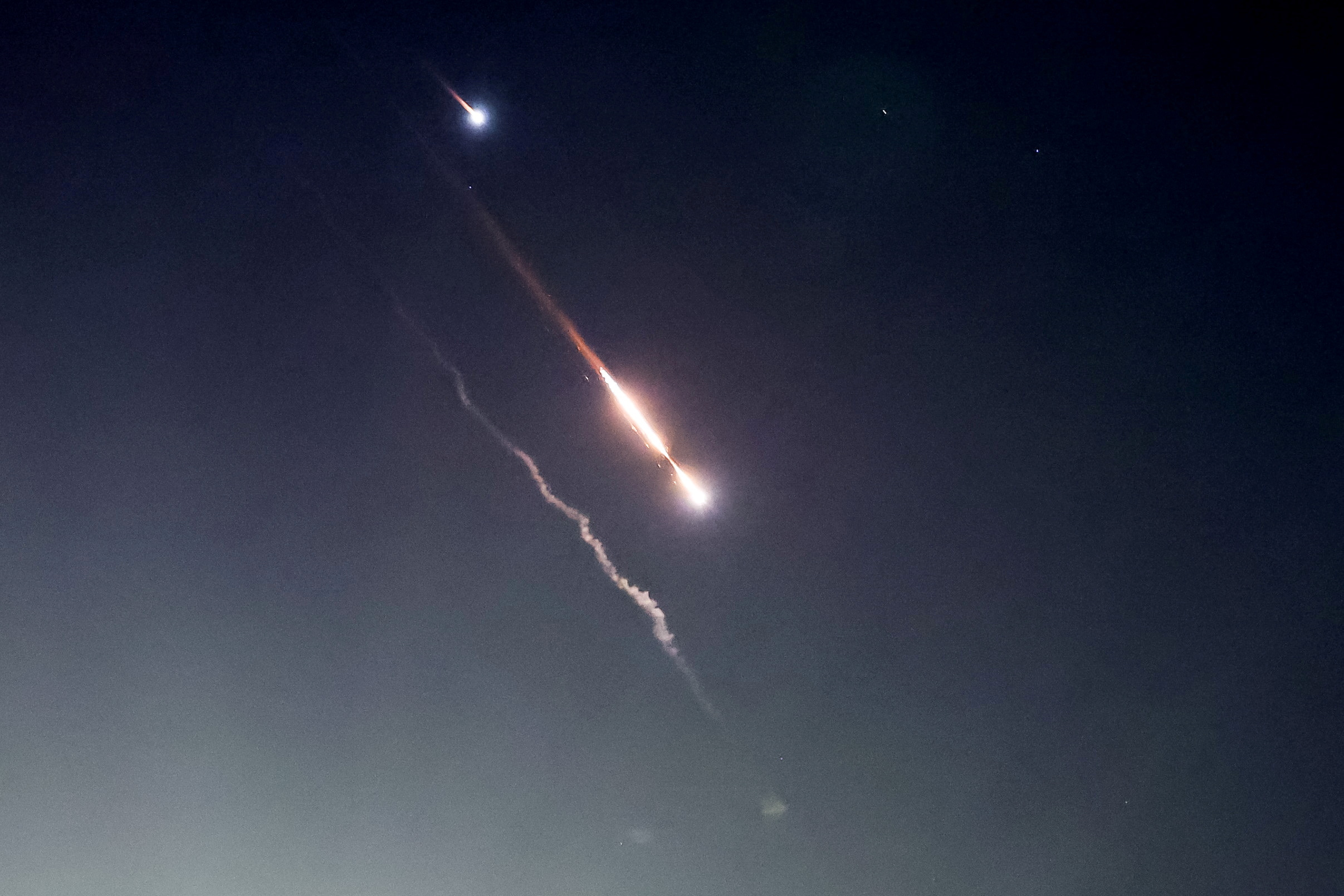 Objects are seen in the sky above Jerusalem after Iran launched drones and missiles towards Israel, in Jerusalem April 14, 2024. REUTERS