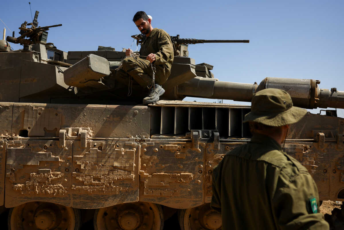 Israeli soldiers conduct some maintenance work on a Merkava tank near the Israel-Gaza border, amid the ongoing conflict between Israel and the Palestinian Islamist group Hamas, on the Israeli side April 3, 2024. REUTERS