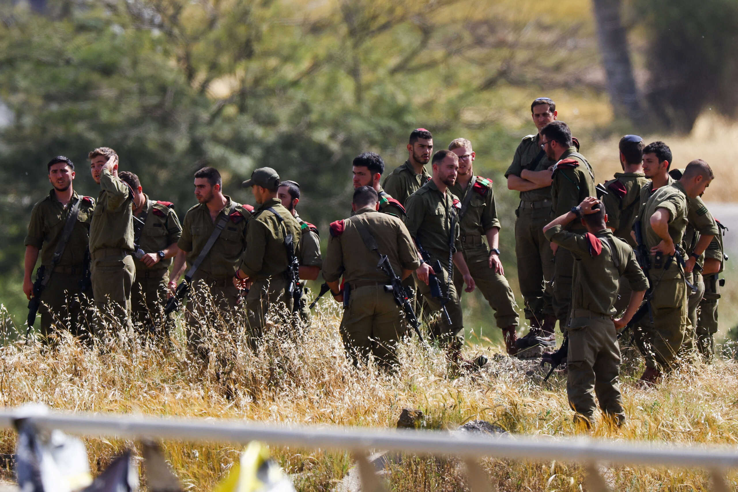 Israeli soldiers gather by the side of a road, amid the ongoing conflict between Israel and the Palestinian Islamist group Hamas, in Israel, April 1, 2024. REUTERS