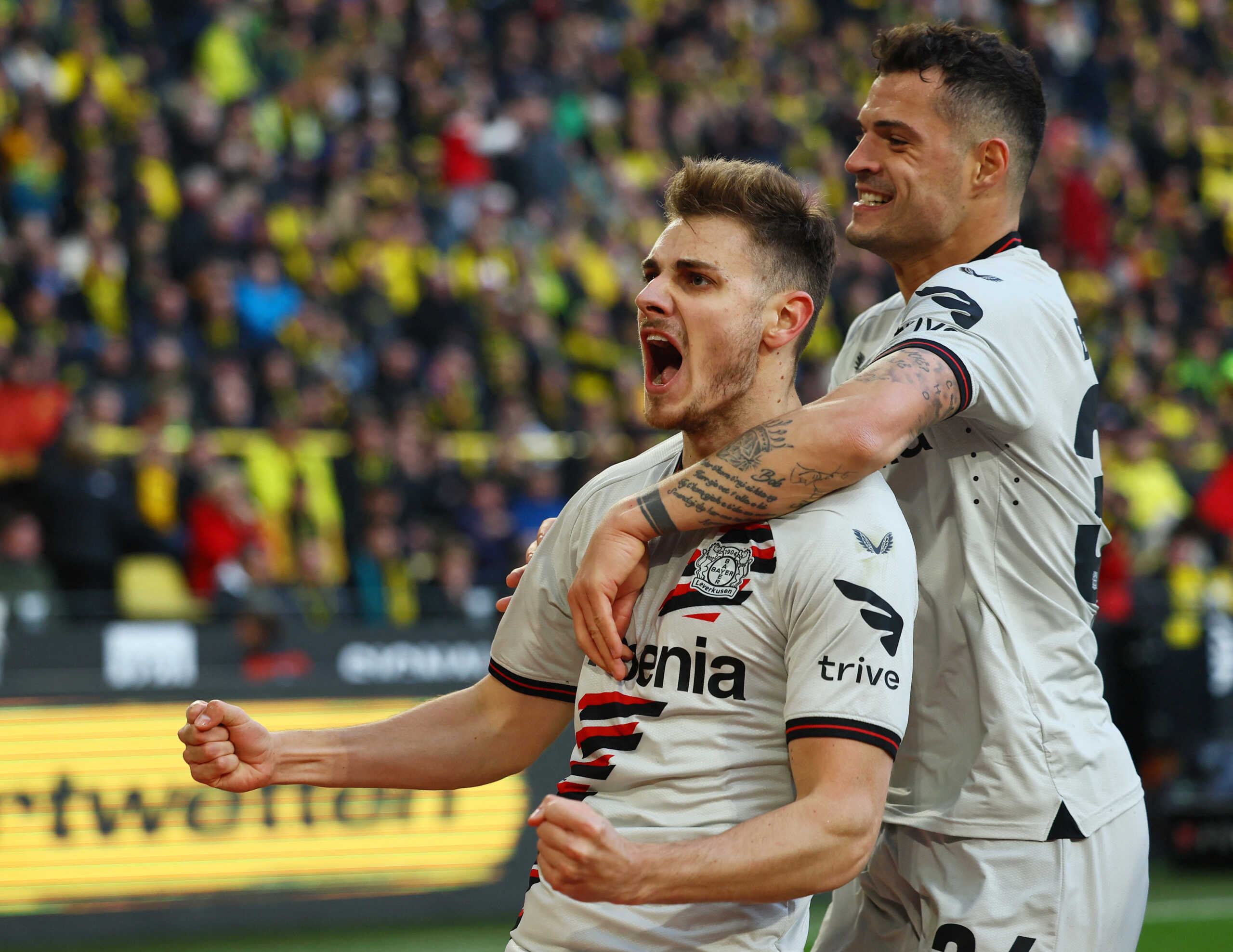 Soccer Football - Bundesliga - Borussia Dortmund v Bayer Leverkusen - Signal Iduna Park, Dortmund, Germany - April 21, 2024 Bayer Leverkusen's Josip Stanisic celebrates scoring their first goal with Granit Xhaka REUTERS