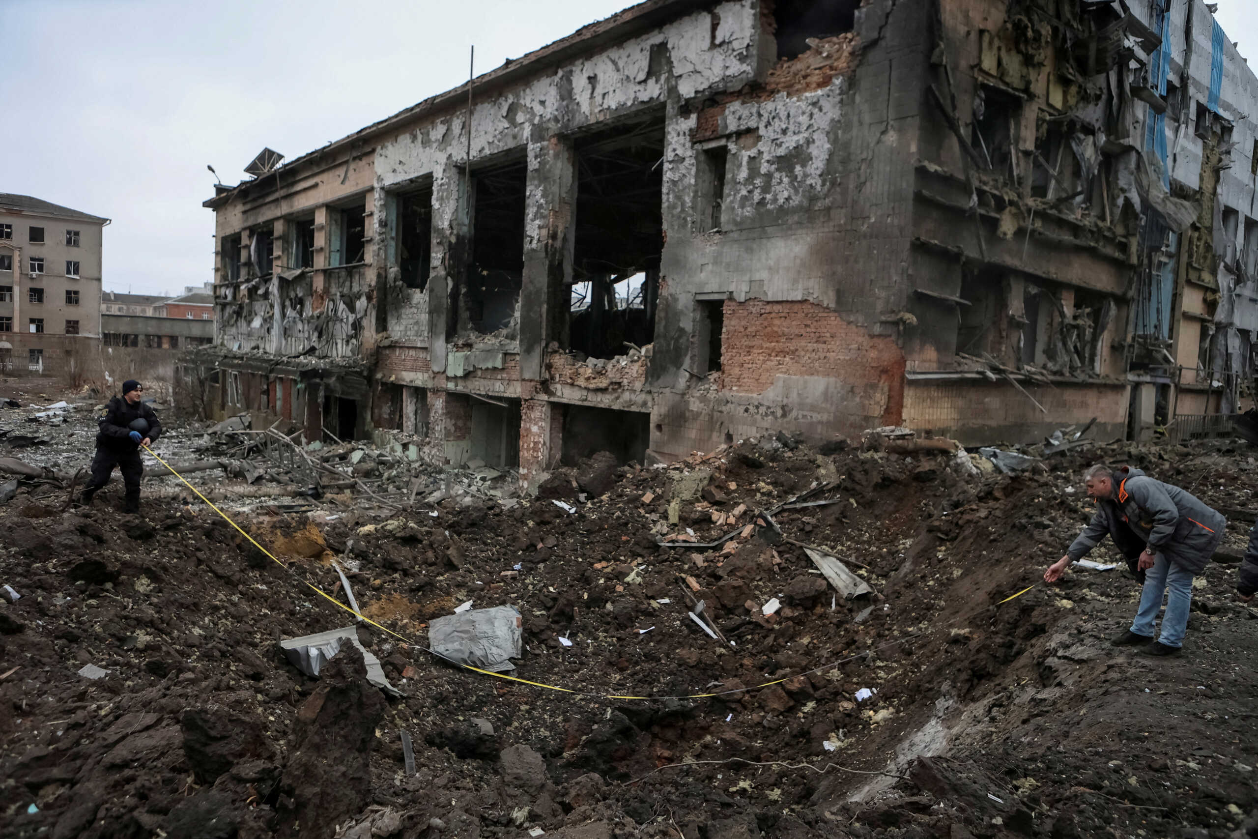 FILE PHOTO: Experts inspect a crater next to a building heavily damaged during a Russian missile attack, amid Russia's attack on Ukraine, in central Kharkiv, Ukraine January 2, 2024. REUTERS