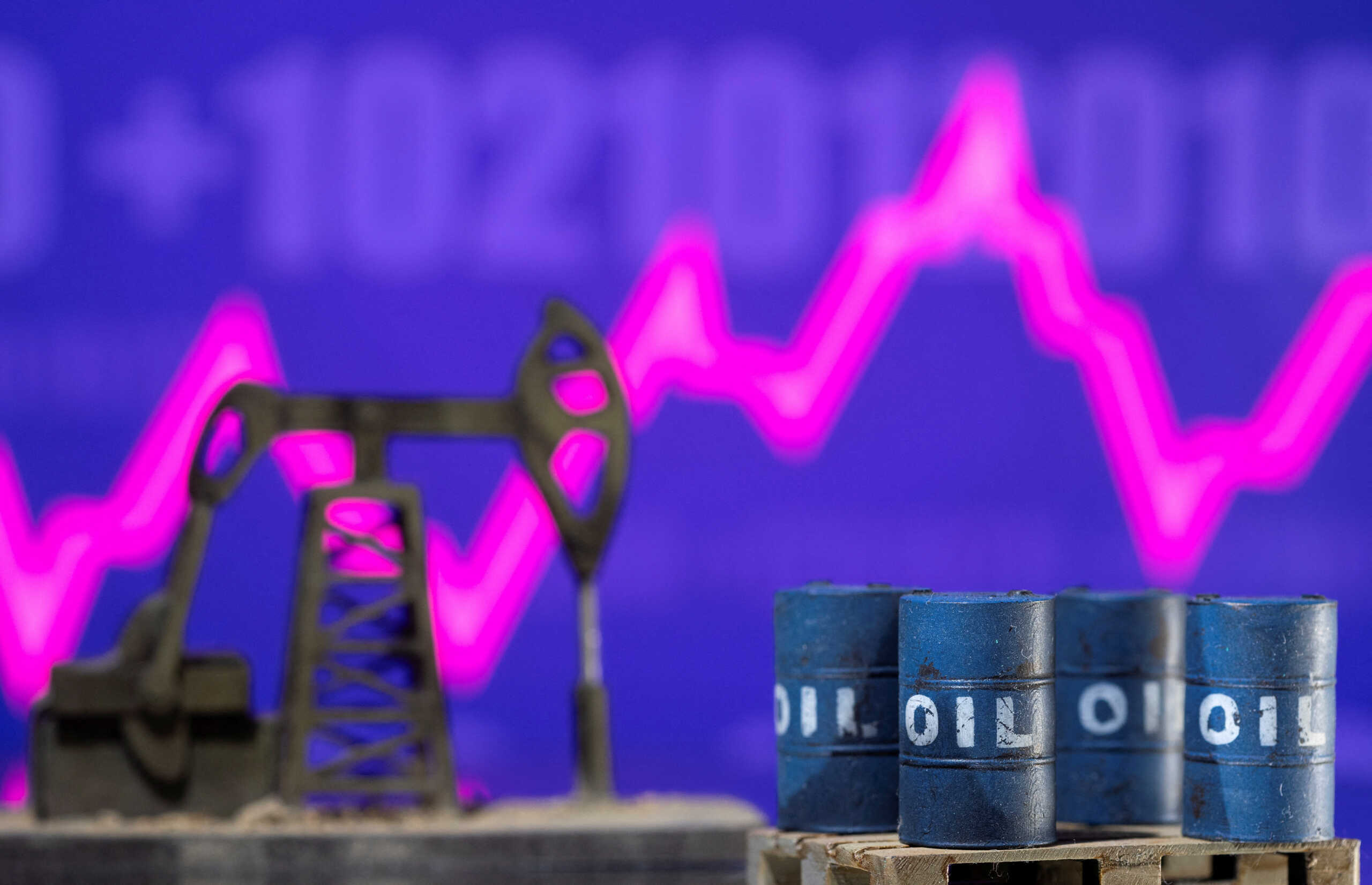 FILE PHOTO: Models of oil barrels and a pump jack are displayed in front of a rising stock graph and "$100" in this illustration taken February 24, 2022. REUTERS