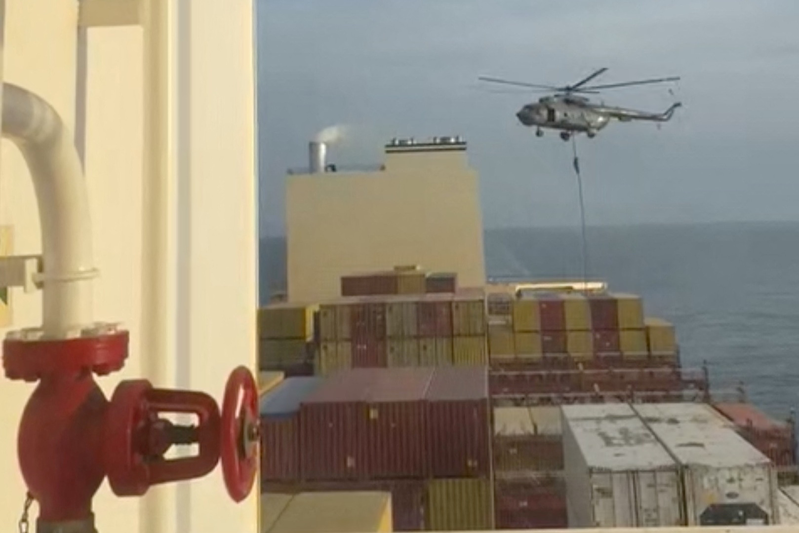 An official slides down a rope during a helicopter raid on MSC Aries ship at sea in this screen grab obtained from a social media video released on April 13, 2024. Video obtained by Reuters