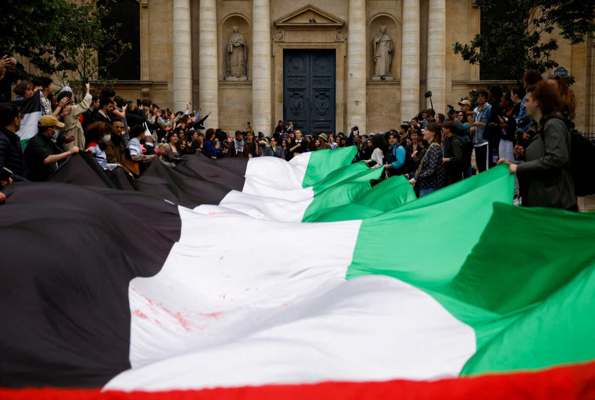 Students hold a giant Palestinian flag as they gather in front of the Sorbonne University in support of Palestinians in Gaza, during the ongoing conflict between Israel and the Palestinian Islamist group Hamas, in Paris, France, April 29, 2024.  REUTERS